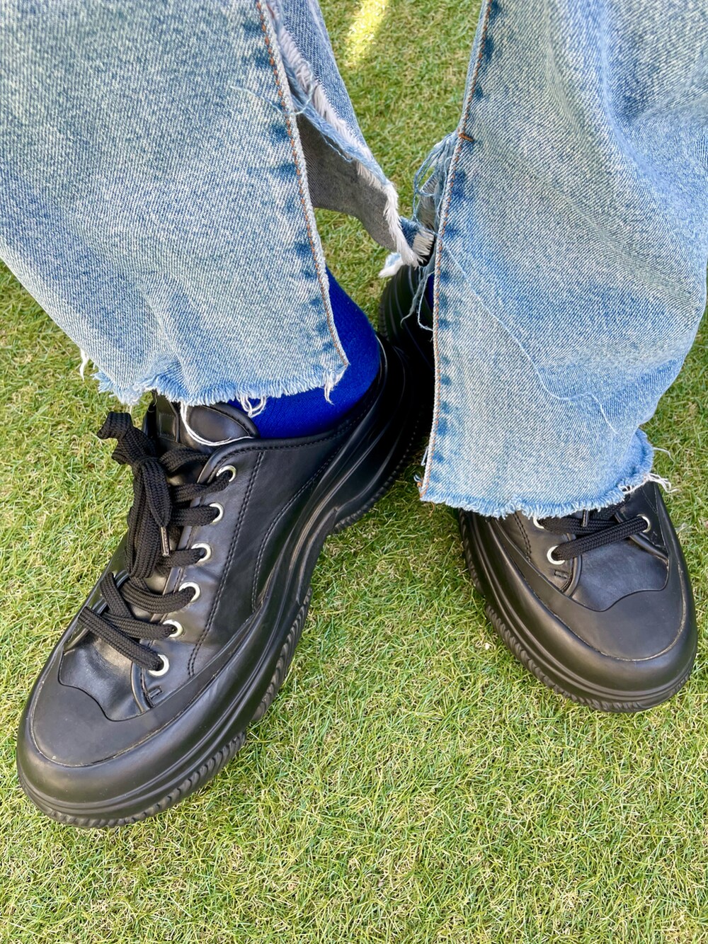 ブラック系のTシャツ/カットソー、ブルー系のデニムパンツ、ブラック系のスニーカーを着用したレディースの秋コーディネートの4枚目の写真