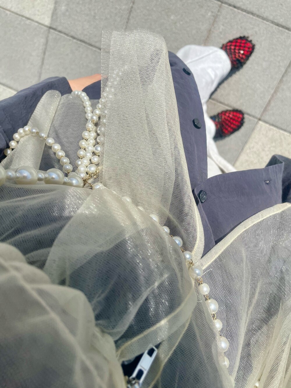 グレー系のスウェットパンツ、ブラック系のサンダル、ベージュ系のキャミソールを着用したレディースの春コーディネートの2枚目の写真