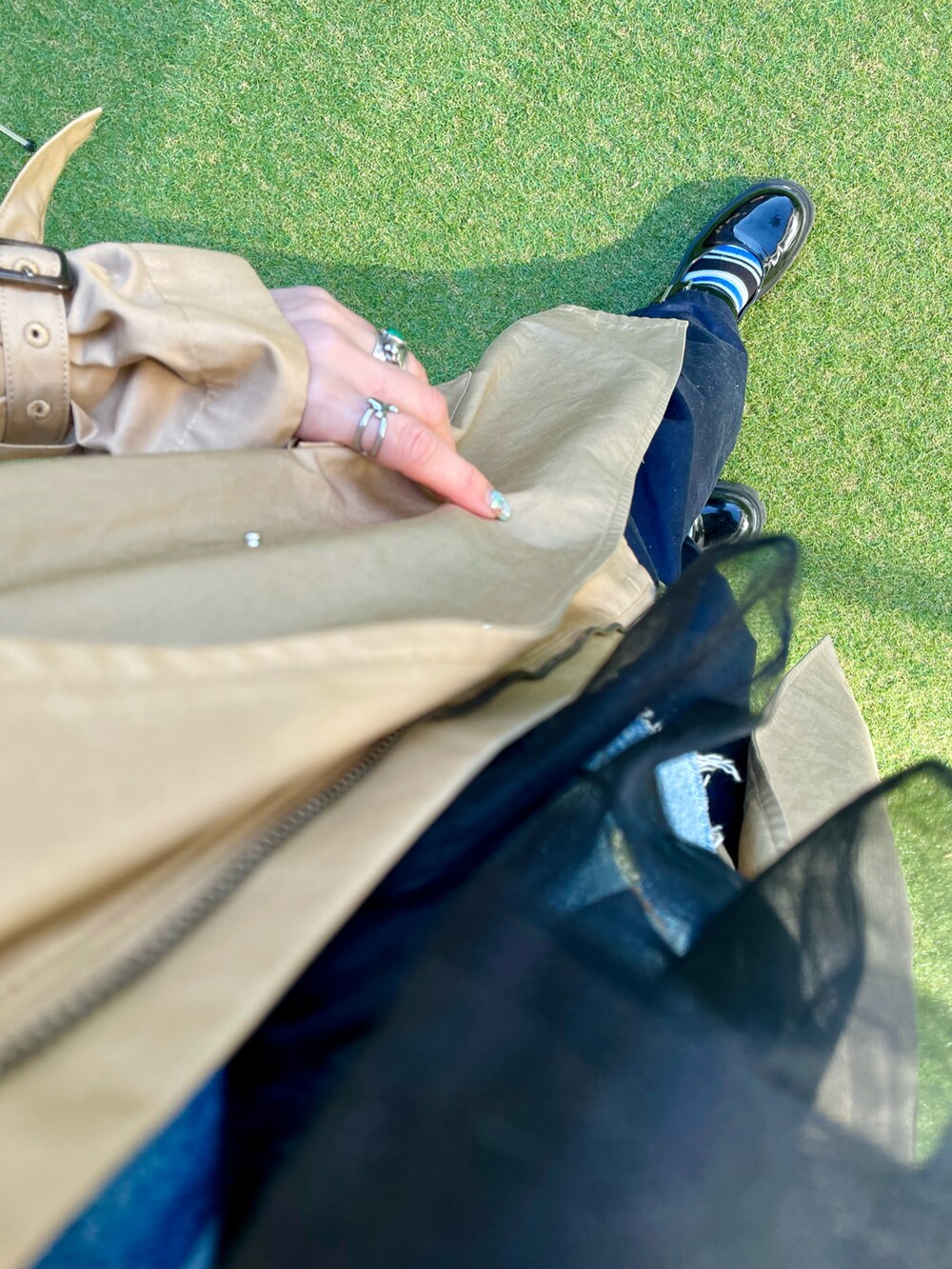 ベージュ系のトレンチコート、ブルー系のデニムジャケット、ブラック系のシャツ/ブラウスを着用したレディースの冬コーディネートの3枚目の写真