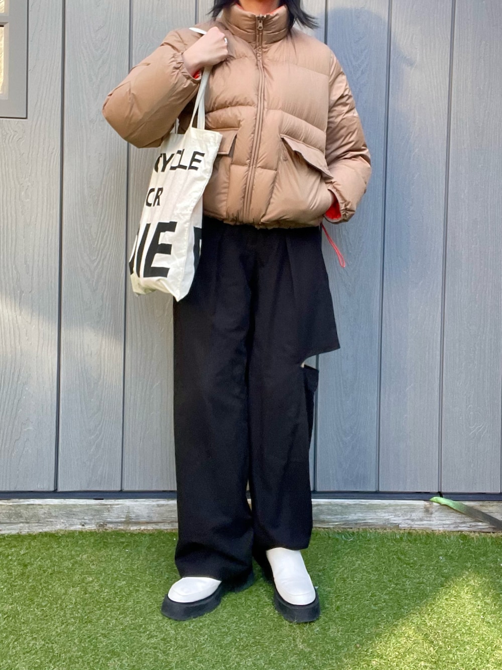 ベージュ系のダウンジャケット/コート、ホワイト系のトートバッグ、ホワイト系のブーツを着用したレディースの冬コーディネートの3枚目の写真