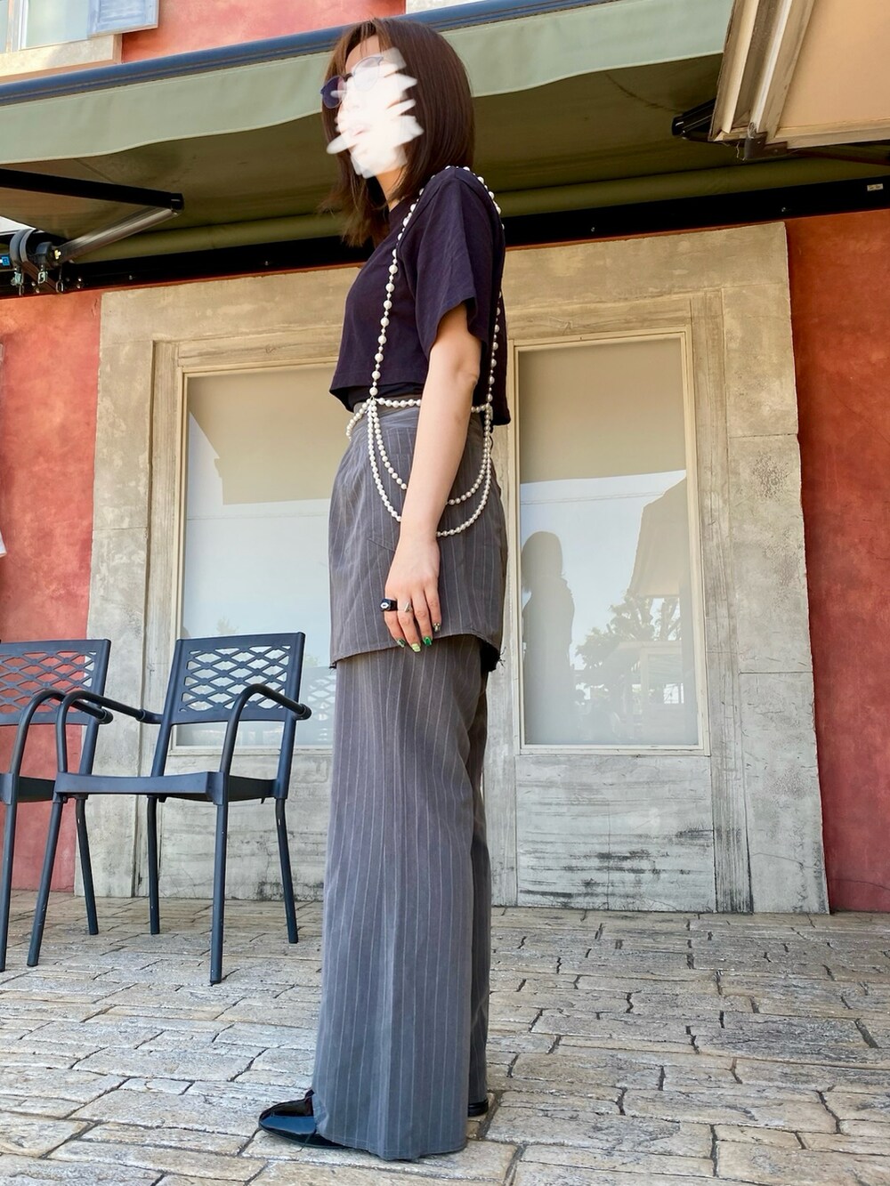 グレー系のスラックス、ブラック系のTシャツ/カットソー、ブラック系のシューズを着用したレディースの春コーディネートの2枚目の写真