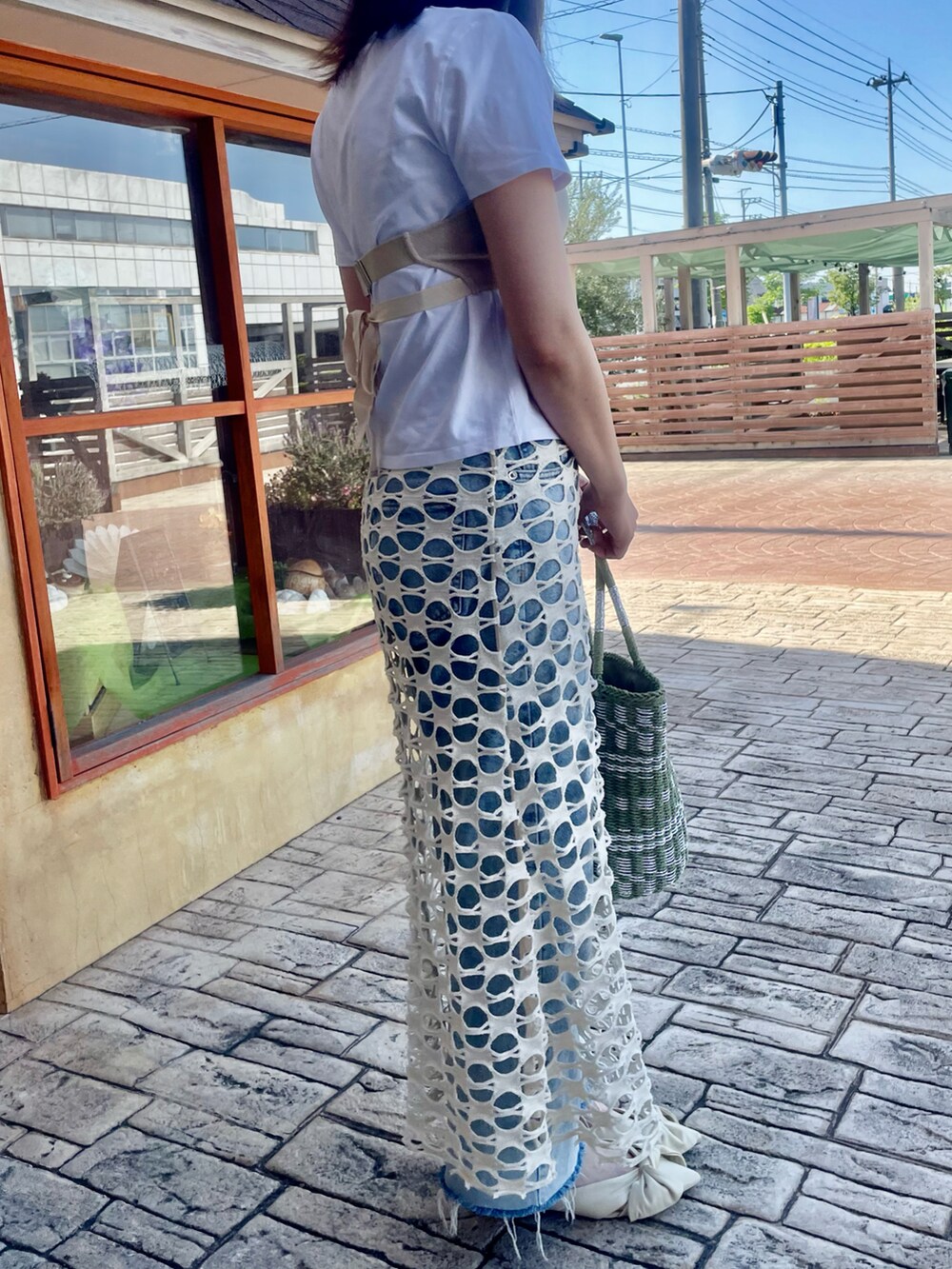 ベージュ系のキャミソール、ホワイト系のTシャツ/カットソー、ホワイト系のスカートを着用したレディースの春コーディネートの2枚目の写真