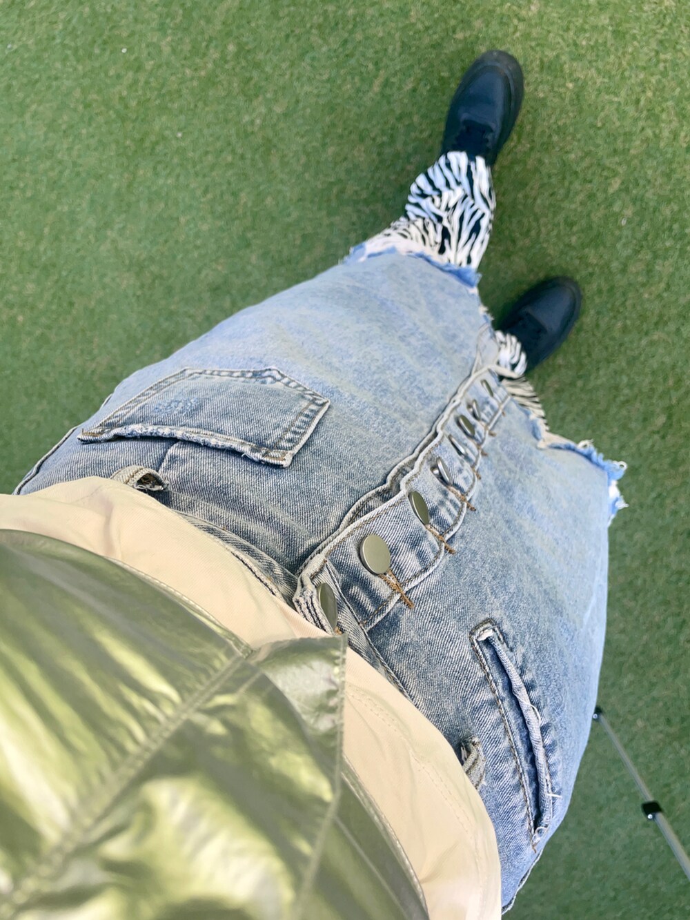 ホワイト系のTシャツ/カットソー、シルバー系のチューブトップ、ブルー系のデニムスカートを着用したレディースの秋コーディネートの4枚目の写真