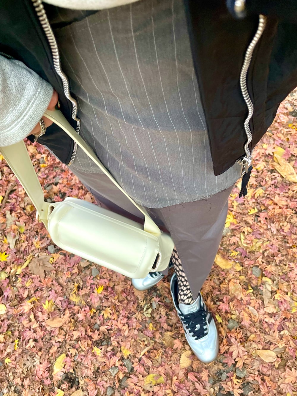 ブラック系のMA-1、シルバー系のトップス、グレー系のスラックスを着用したレディースの冬コーディネートの4枚目の写真