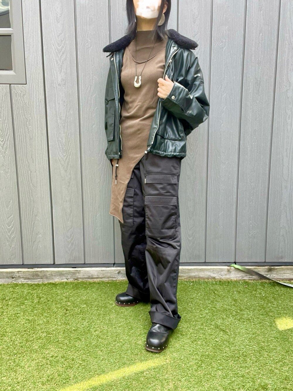 ブラック系のカーゴパンツ、グリーン系のニット/セーター、グリーン系のブルゾンを着用したレディースの冬コーディネートの2枚目の写真