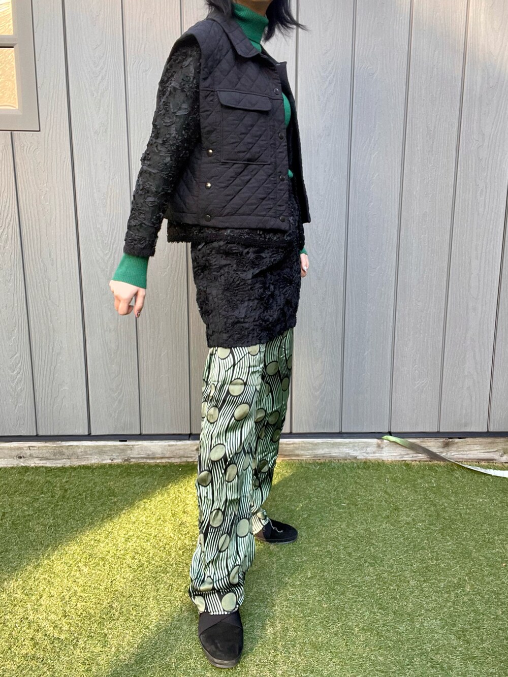 ブラック系のベスト、ブラック系のスカート、グリーン系のその他パンツを着用したレディースの秋コーディネートの3枚目の写真