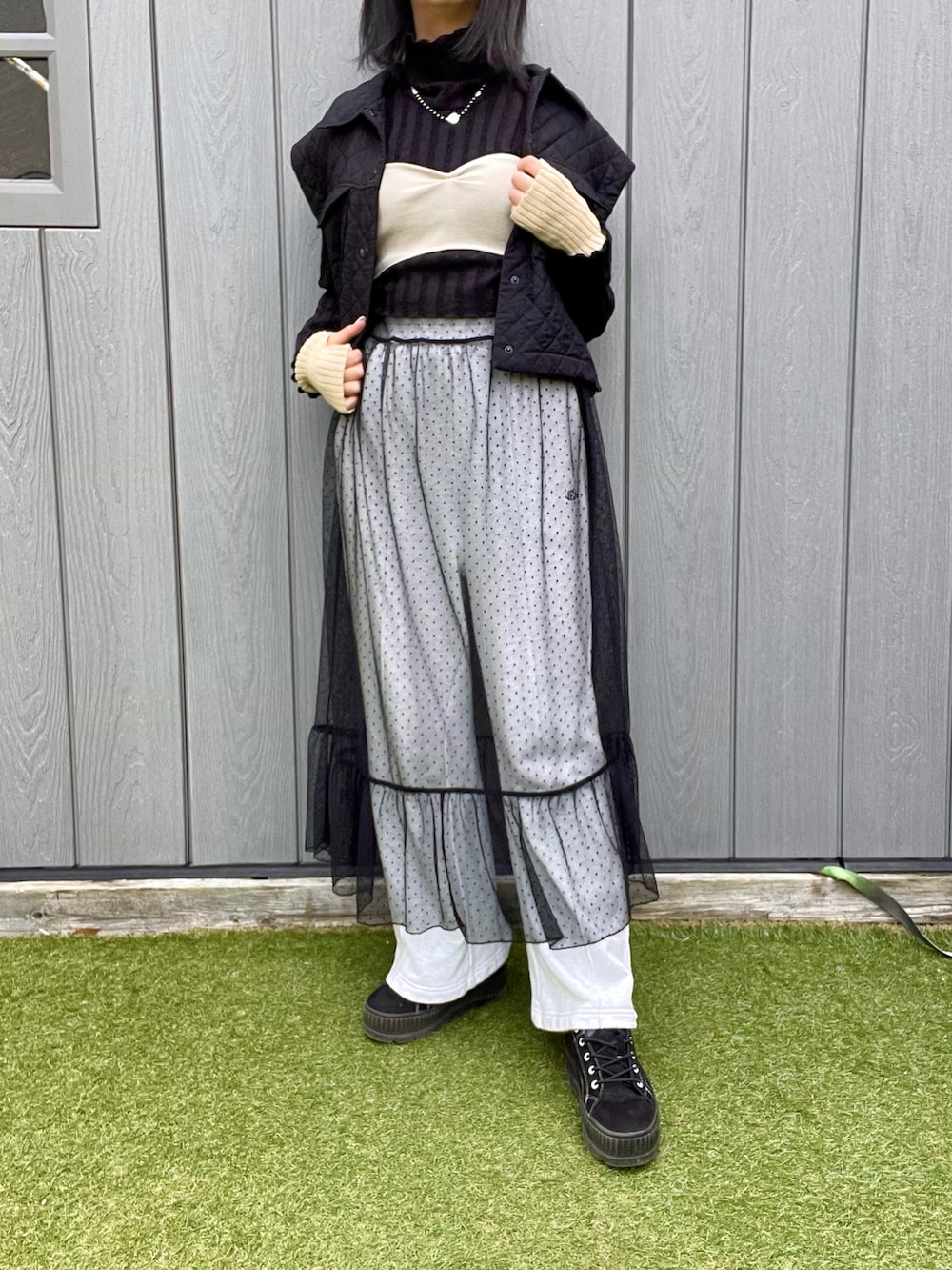 ブラック系のベスト、ブラック系のワンピース、グレー系のスウェットパンツを着用したレディースの冬コーディネートの2枚目の写真