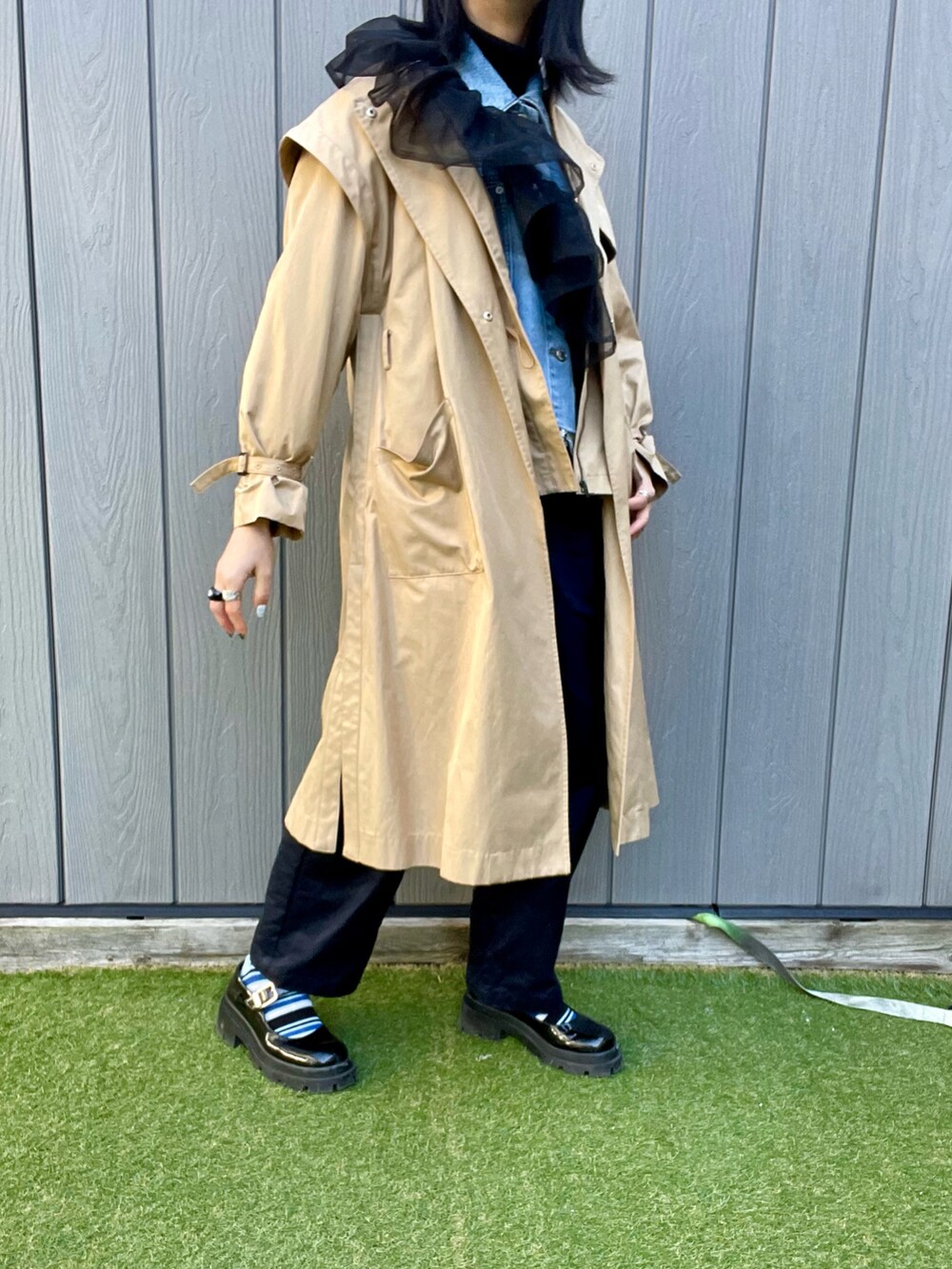 ベージュ系のトレンチコート、ブルー系のデニムジャケット、ブラック系のシャツ/ブラウスを着用したレディースの冬コーディネートの2枚目の写真