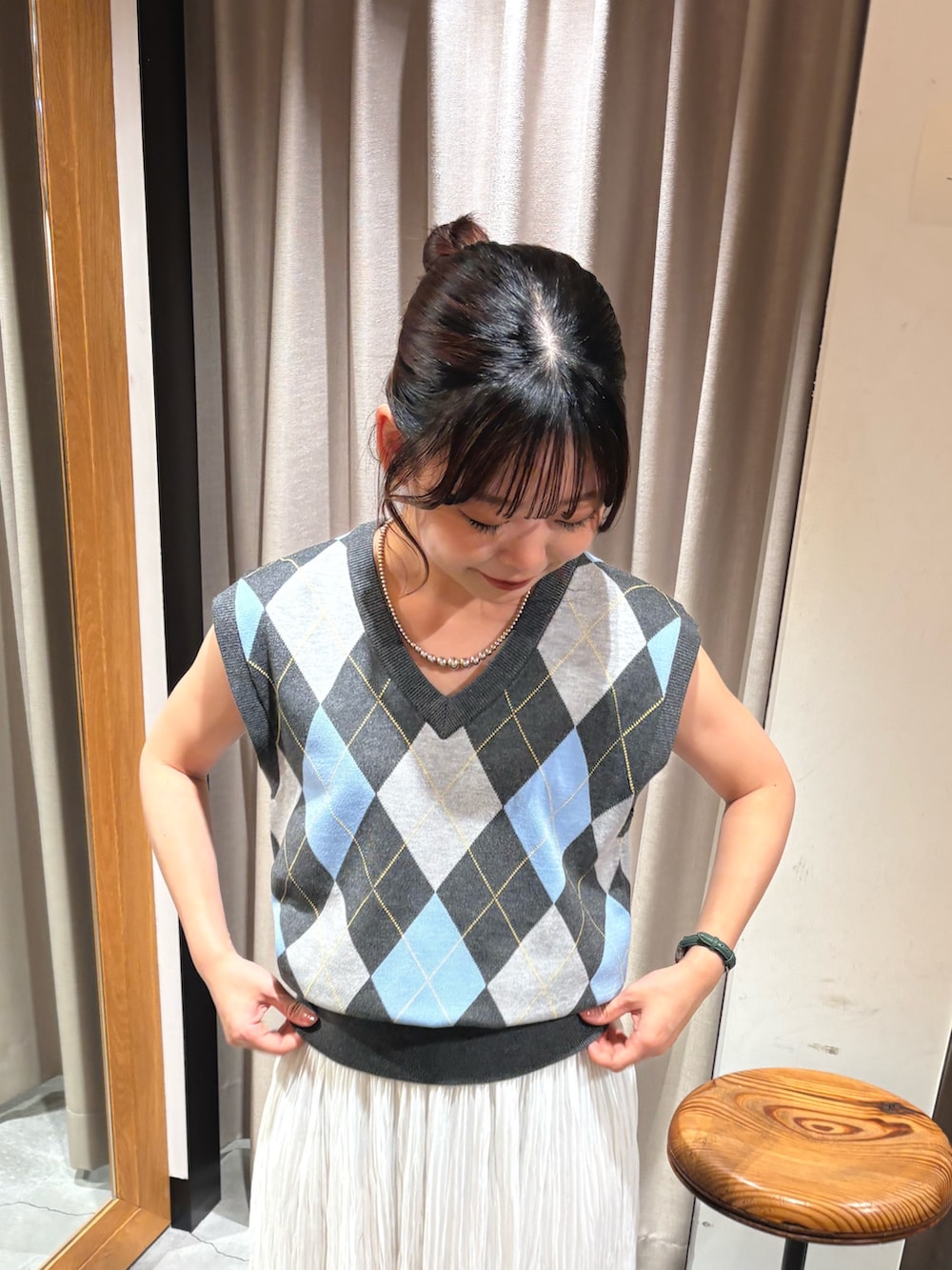 ベージュ系のサンダル、ホワイト系のスカート、グレー系のベストを着用したレディースの夏コーディネートの2枚目の写真
