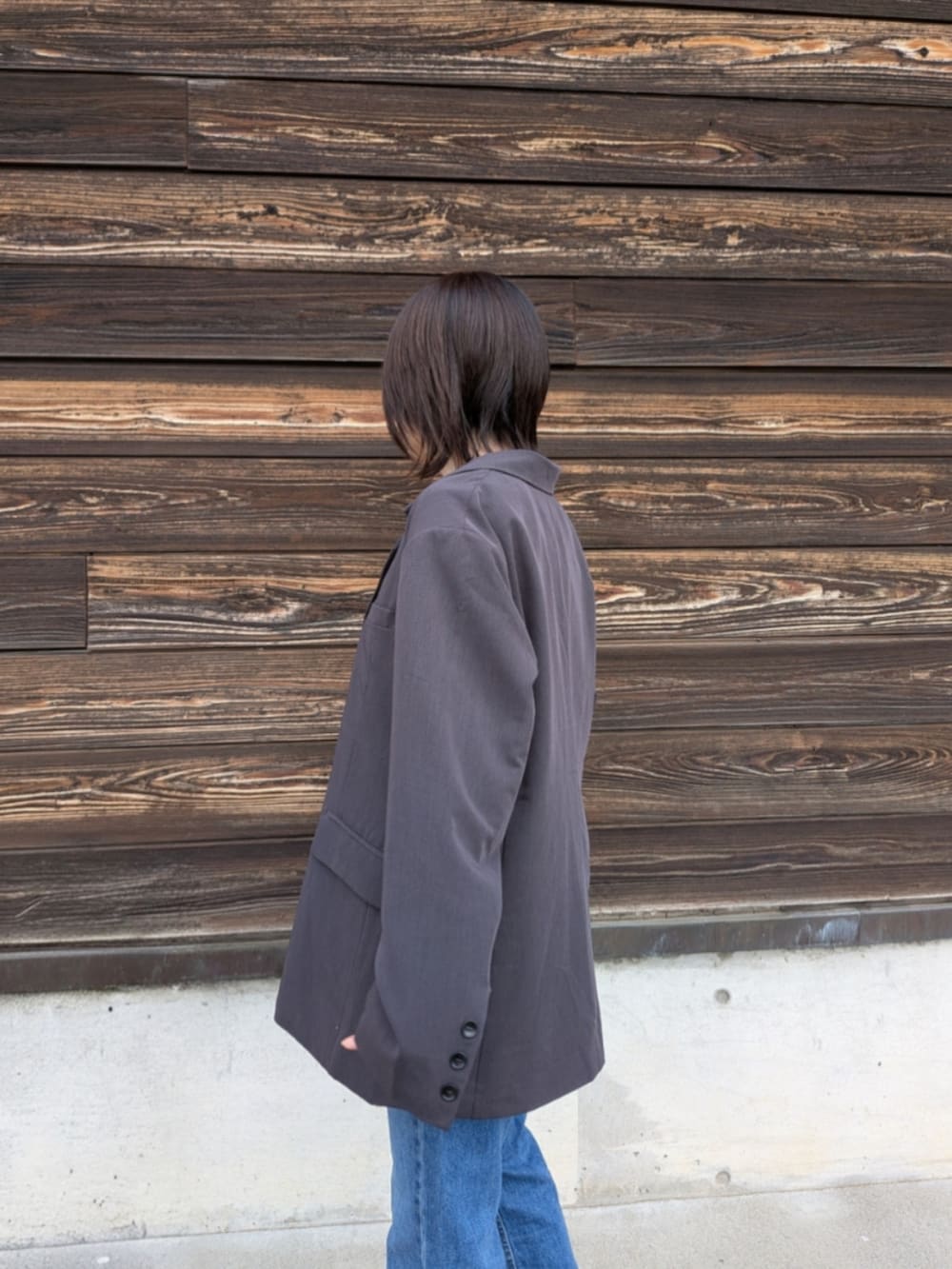 グレー系のテーラードジャケット、ブラック系のキャミソール、ホワイト系のショルダーバッグを着用したレディースの春コーディネートの5枚目の写真