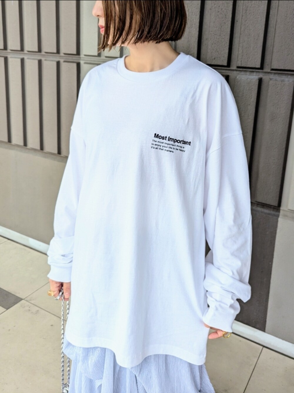 ホワイト系のTシャツ/カットソー、ブラック系のブーツ、シルバー系のワンピースを着用したレディースの秋コーディネートの3枚目の写真