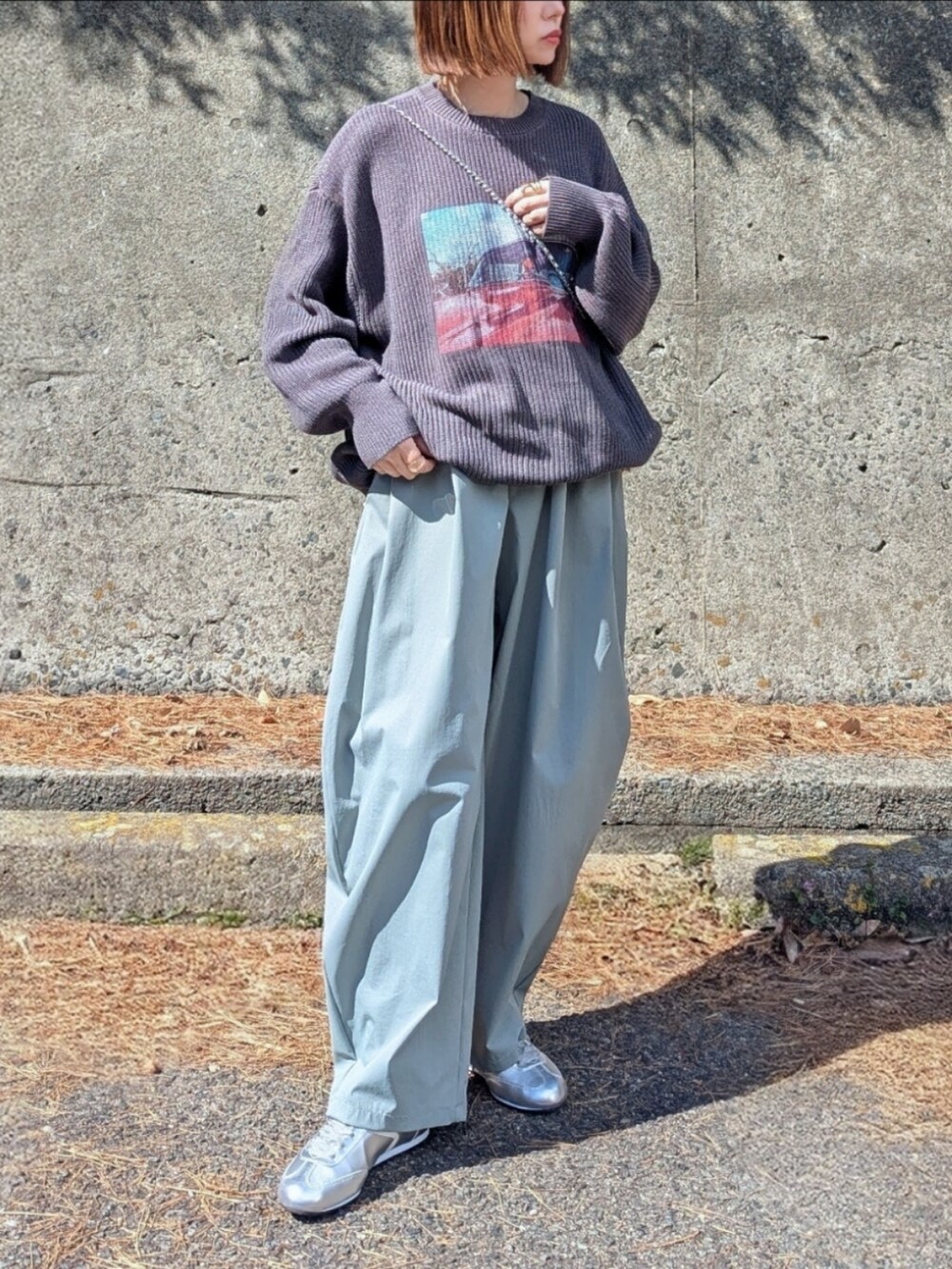 グレー系のニット/セーター、グリーン系のその他パンツ、シルバー系のショルダーバッグを着用したレディースの春コーディネートの2枚目の写真