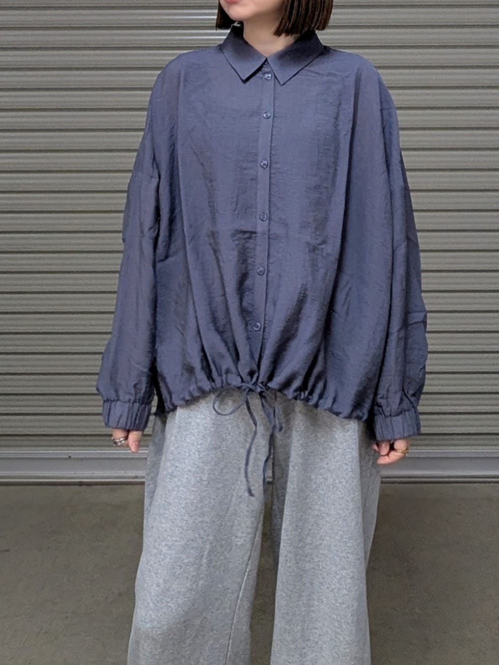 グレー系のシャツ/ブラウス、シルバー系のトートバッグ、グレー系のパンツを着用したレディースの春コーディネートの2枚目の写真