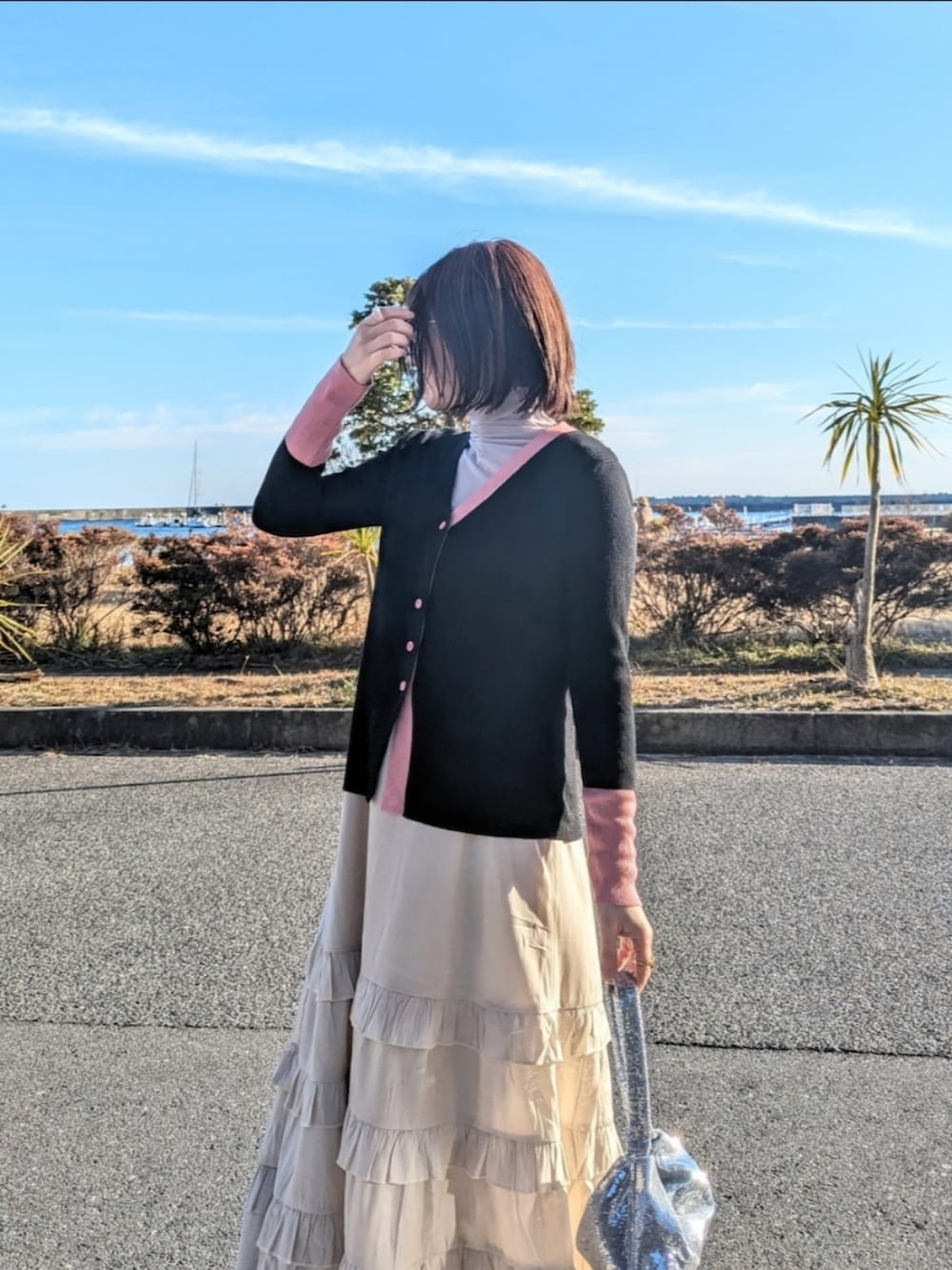 ブラック系のカーディガン/ボレロ、グレー系のTシャツ/カットソー、ベージュ系のワンピースを着用したレディースの冬コーディネートの3枚目の写真