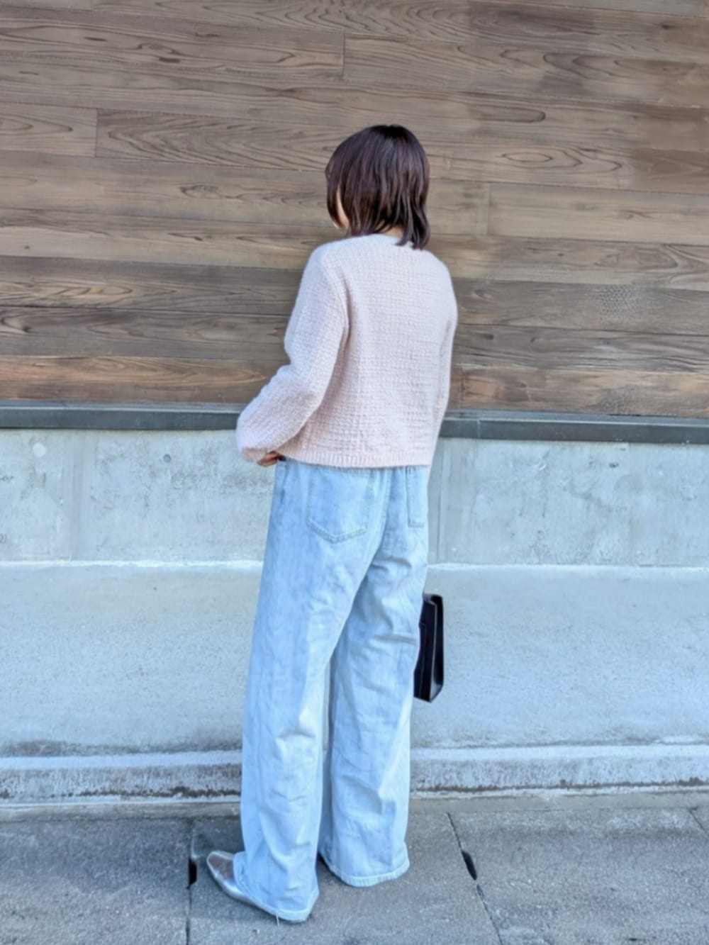 ブルー系のデニムパンツ、ブラック系のショルダーバッグ、ピンク系のカーディガン/ボレロを着用したレディースの春コーディネートの5枚目の写真