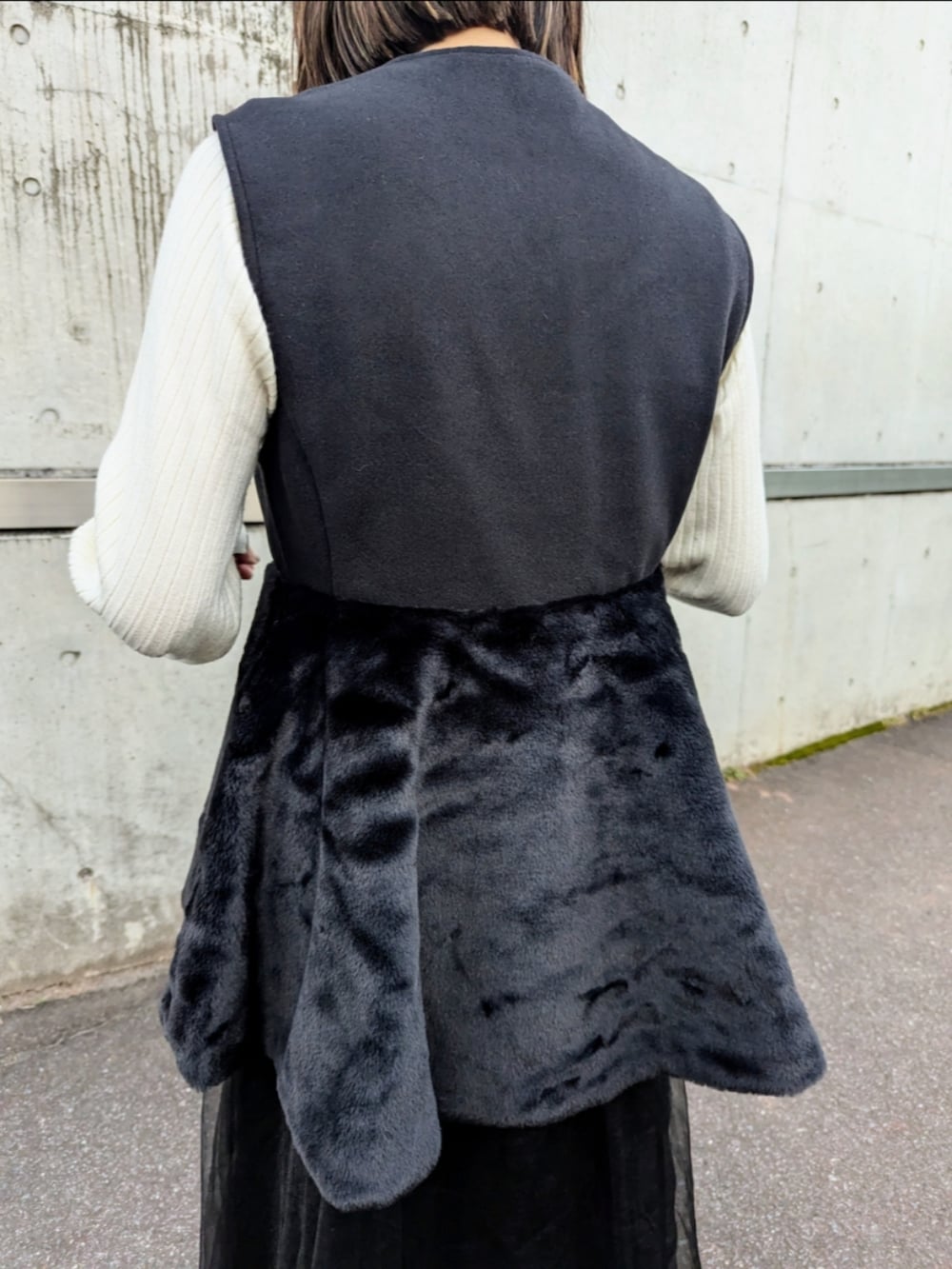 ブラック系のベスト、ホワイト系のニット/セーター、ベージュ系のショルダーバッグを着用したレディースの秋コーディネートの4枚目の写真