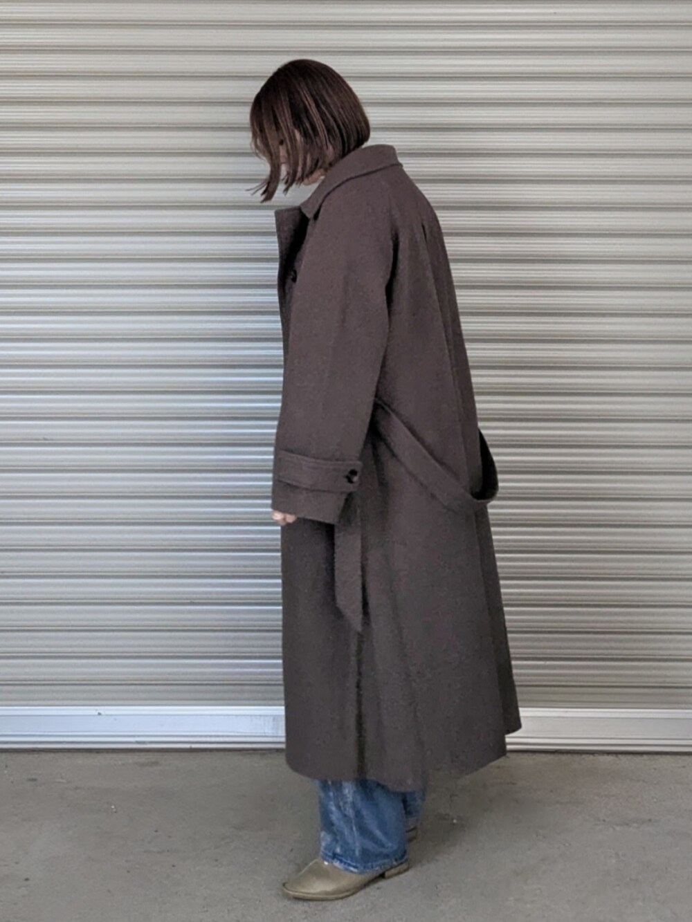 グリーン系のニット/セーター、ブラウン系のステンカラーコート、グリーン系のパンプスを着用したレディースの冬コーディネートの2枚目の写真