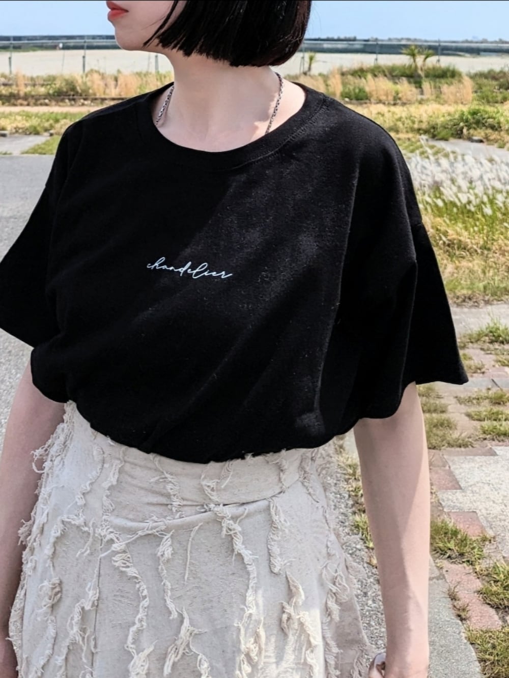 ブラック系のTシャツ/カットソー、ホワイト系のスカート、ピンク系のカーディガン/ボレロを着用したレディースの春コーディネートの2枚目の写真