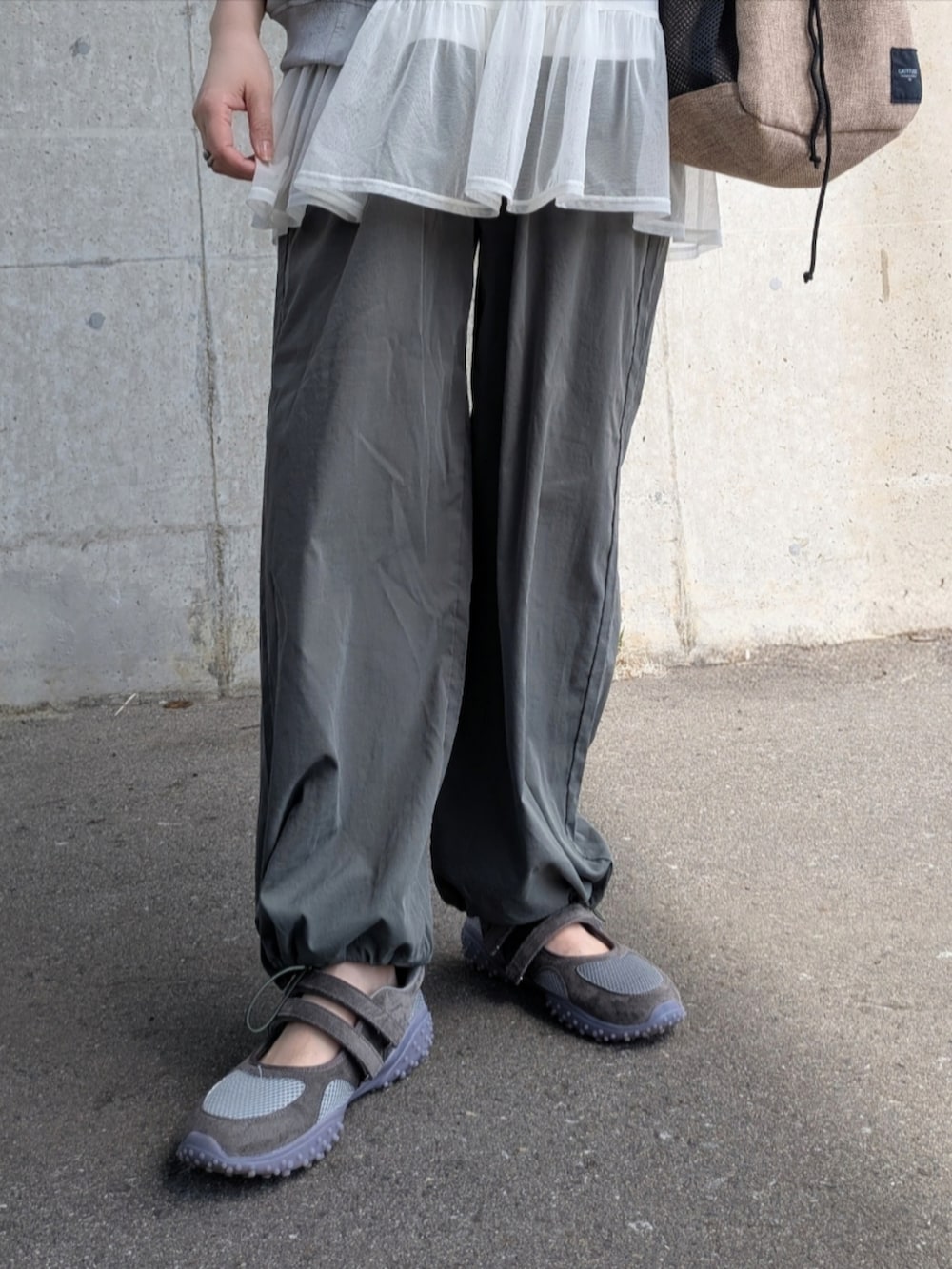 グリーン系のブルゾン、グリーン系のカーゴパンツ、ベージュ系のショルダーバッグを着用したレディースの春コーディネートの2枚目の写真