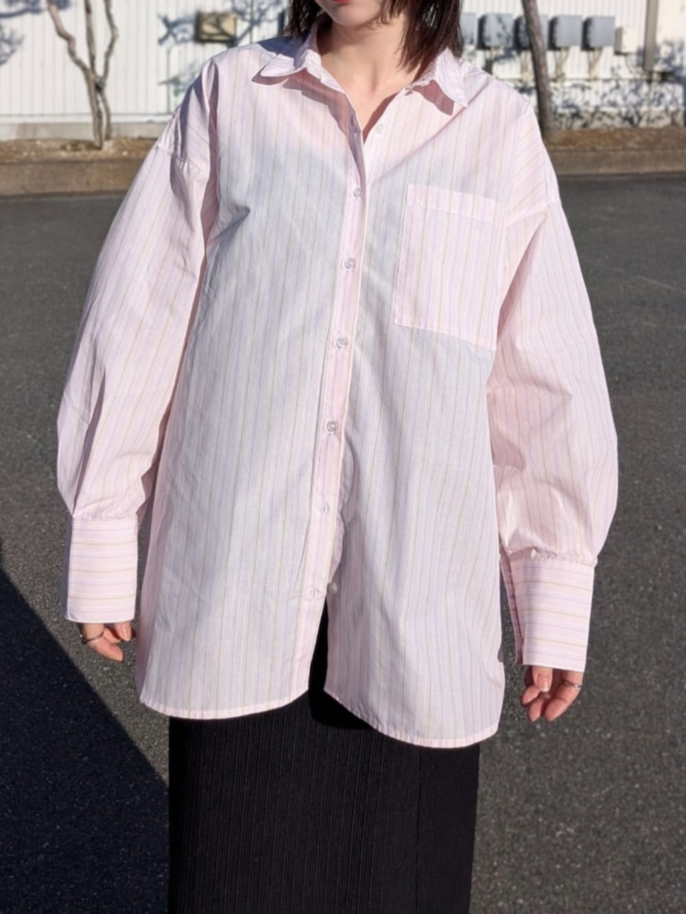 ピンク系のシャツ/ブラウス、ブルー系のデニムジャケット、ブラック系のパンプスを着用したレディースの春コーディネートの4枚目の写真