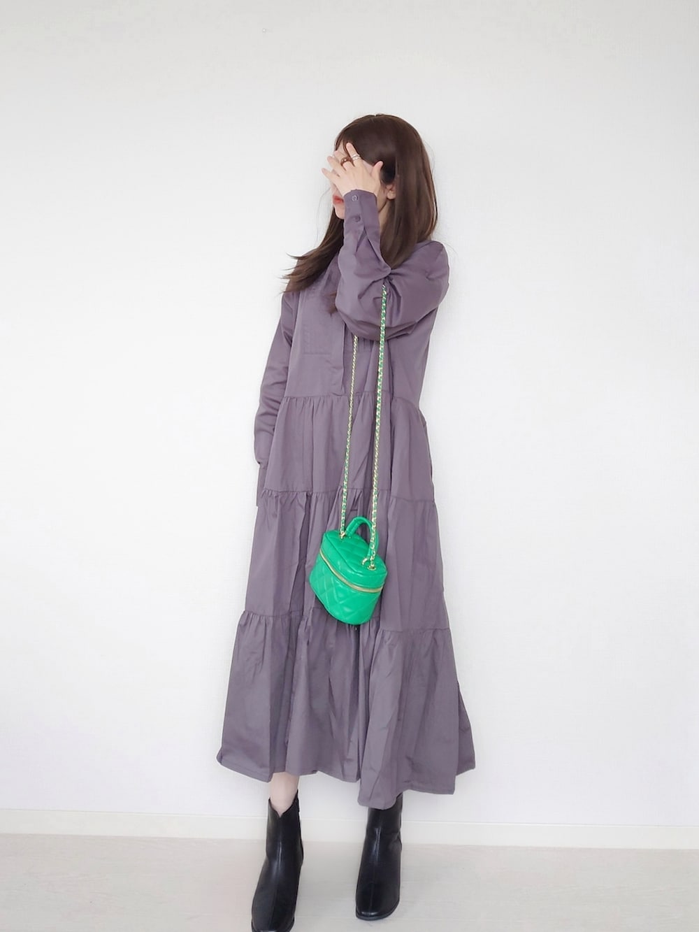 ブラック系のシャツワンピース、グリーン系のショルダーバッグ、ブラック系のブーツを着用したレディースの秋コーディネートの2枚目の写真