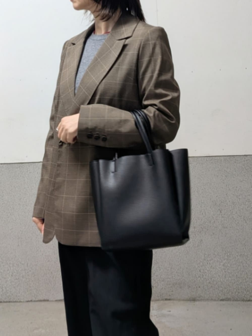 ブラック系のパンプス、ブラック系のトートバッグを着用したレディースの春コーディネートの4枚目の写真