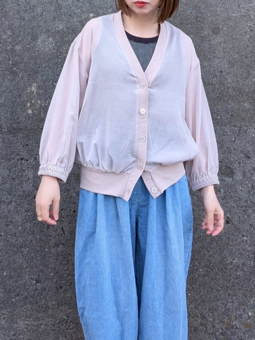 ベージュ系のブルゾン、ブルー系のデニムパンツ、ブラック系のタンクトップを着用したレディースの春コーディネートの3枚目の写真