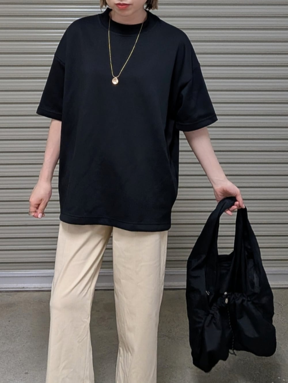 ブラック系のTシャツ/カットソー、ブラック系のトートバッグ、ブラック系のサンダルを着用したレディースの夏コーディネートの2枚目の写真