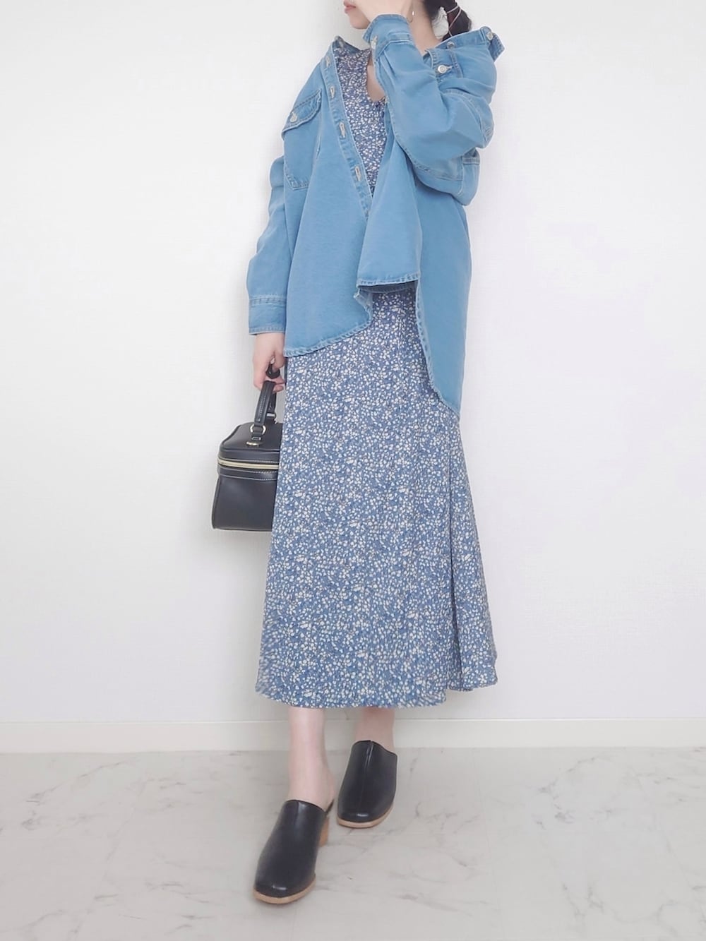 ブルー系のワンピース、ブラック系のバッグ、ブルー系のデニムジャケットを着用したレディースの春コーディネートの2枚目の写真