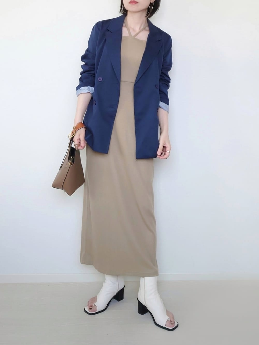 ベージュ系のワンピース、ブルー系のテーラードジャケット、ホワイト系のサンダルを着用したレディースの春コーディネートの2枚目の写真