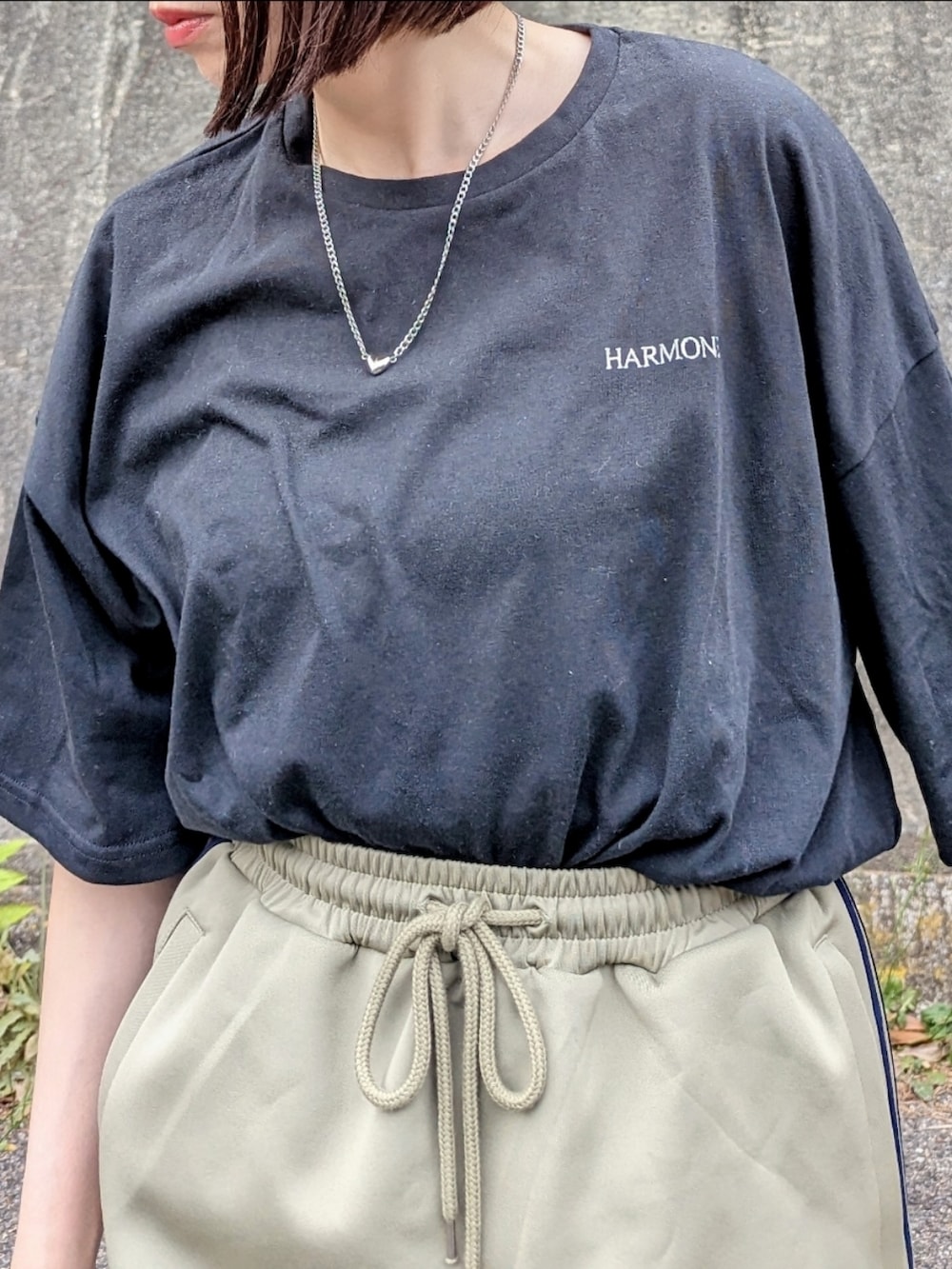 ブラック系のTシャツ/カットソー、ブルー系のスカート、ベージュ系のショルダーバッグを着用したレディースの春コーディネートの5枚目の写真