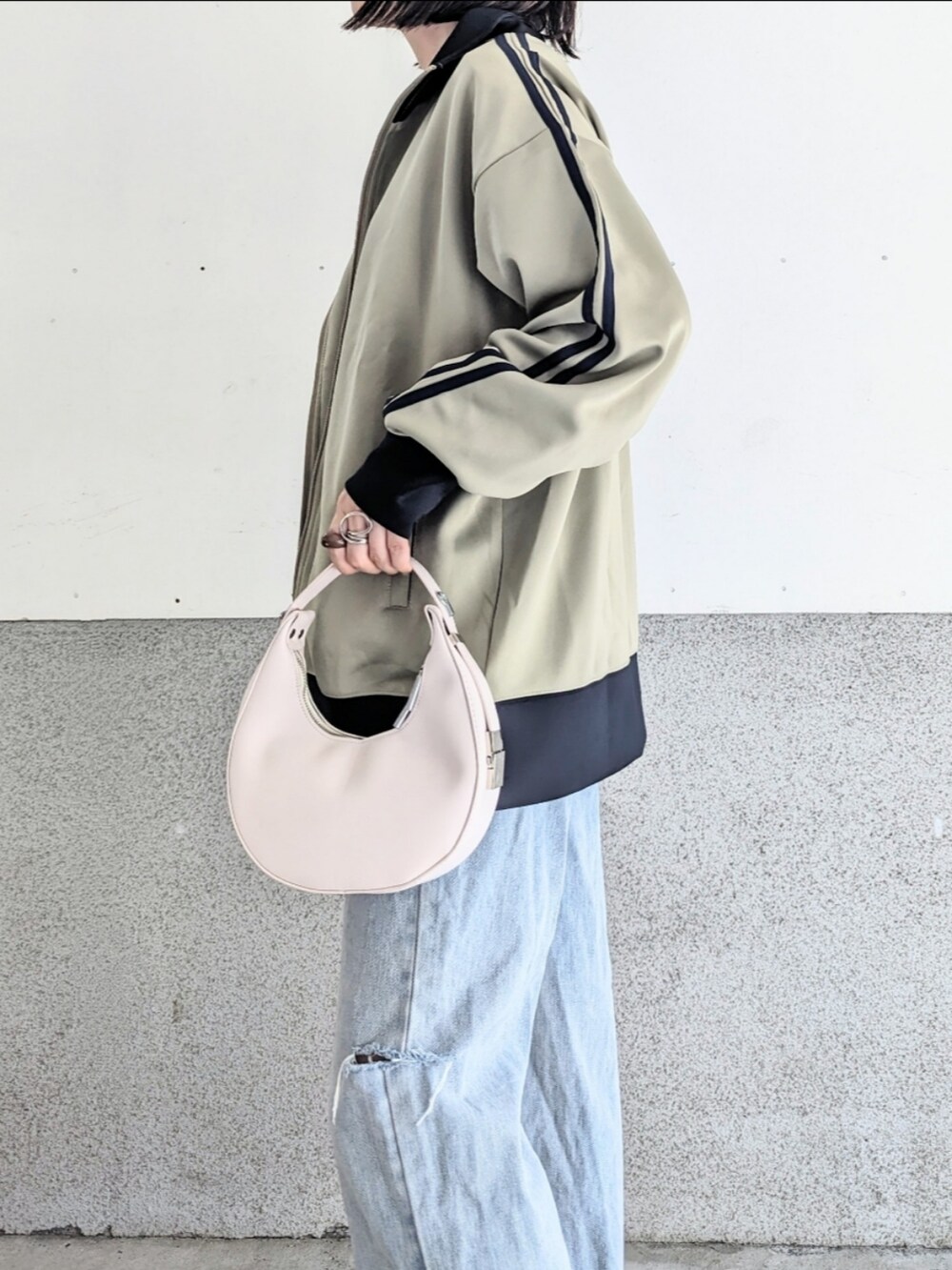ベージュ系のジャージ、ホワイト系のTシャツ/カットソー、ホワイト系のハンドバッグを着用したレディースの秋コーディネートの3枚目の写真