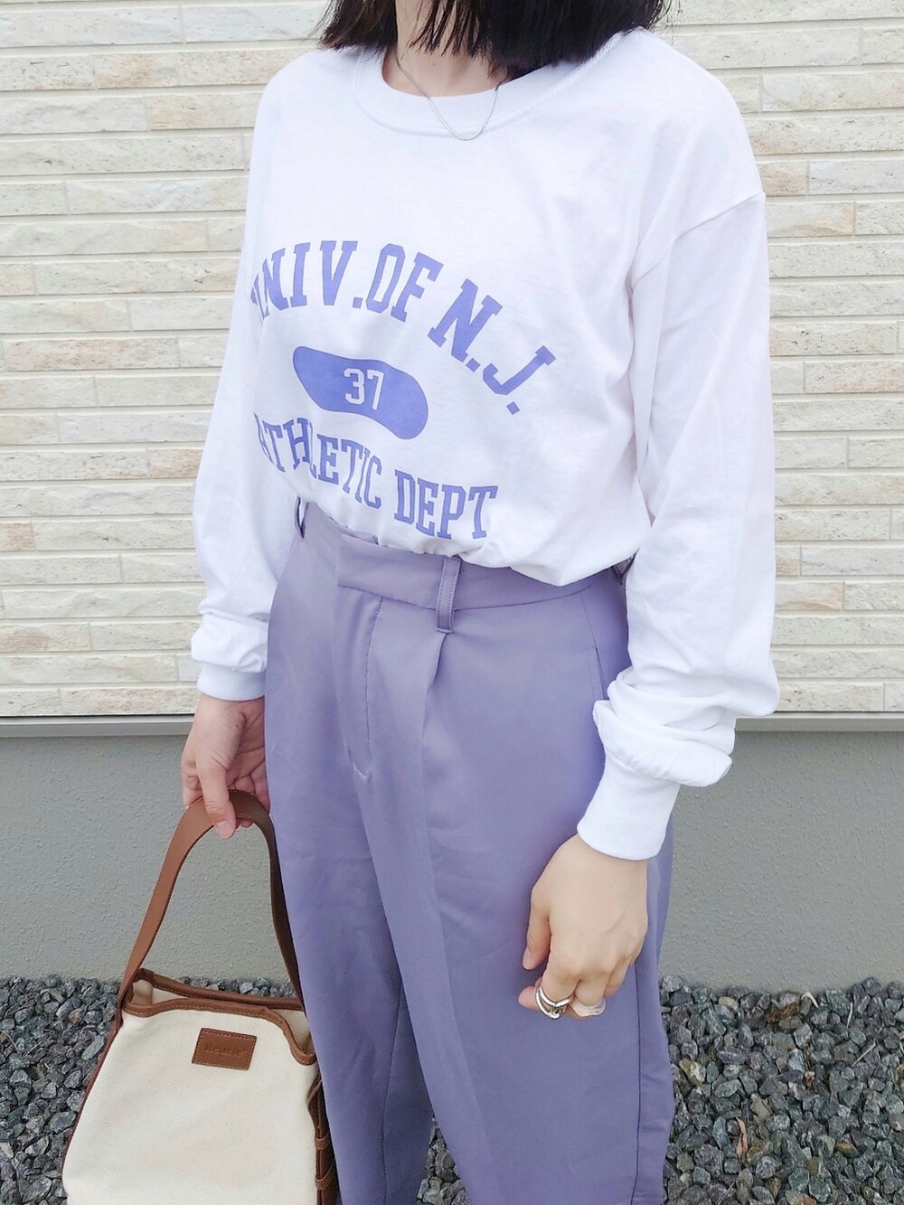 ホワイト系のTシャツ/カットソー、ブラウン系のハンドバッグ、グレー系のシューズを着用したレディースの夏コーディネートの2枚目の写真