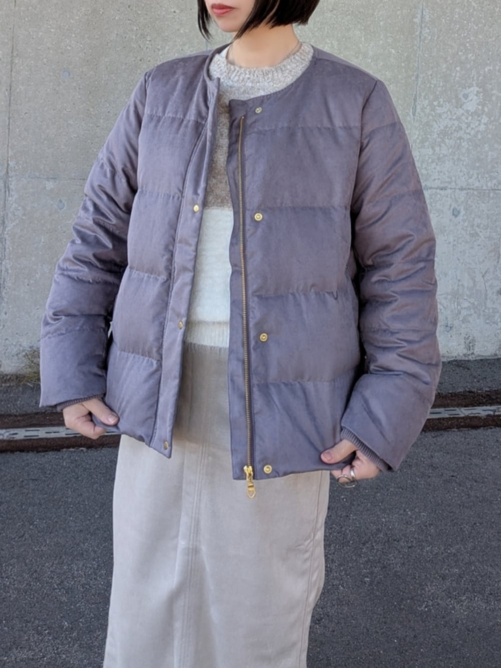 ブラウン系のダウンジャケット/コート、ベージュ系のニット/セーター、ベージュ系のスカートを着用したレディースの冬コーディネートの3枚目の写真