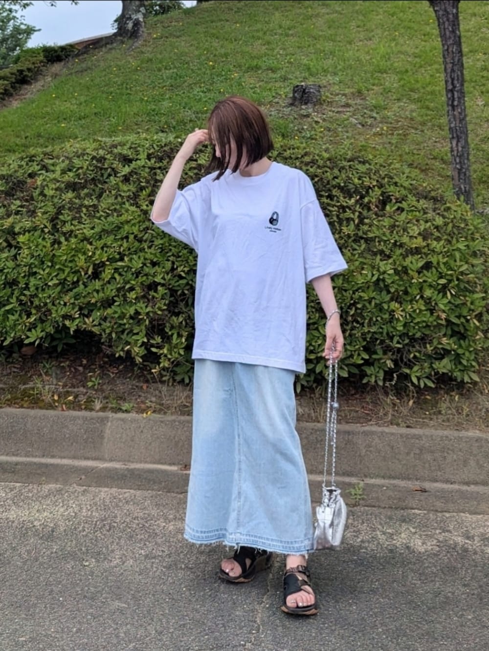 ホワイト系のTシャツ/カットソー、ブルー系のスカート、ブラウン系のサンダルを着用したレディースの夏コーディネートの5枚目の写真