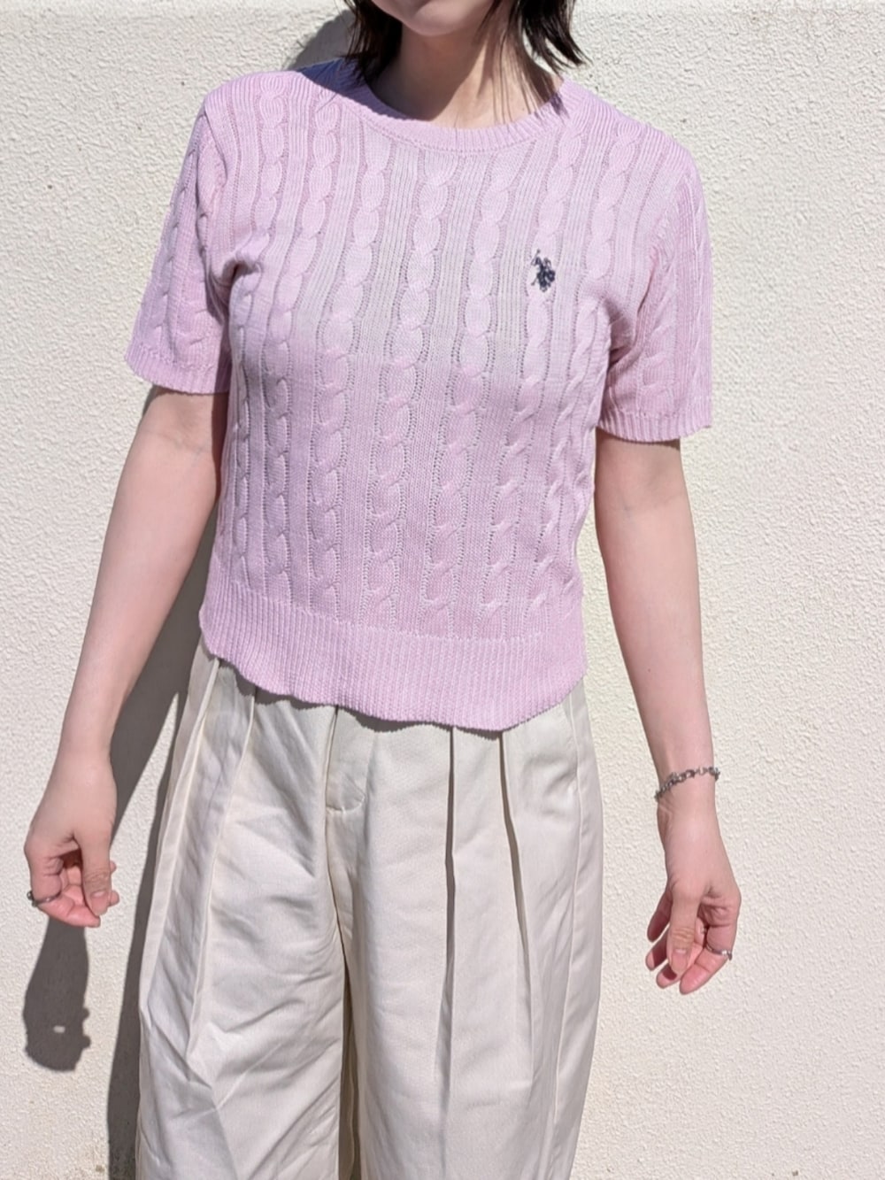 ピンク系のニット/セーター、ブルー系のデニムジャケット、ブラック系のショルダーバッグを着用したレディースの春コーディネートの3枚目の写真