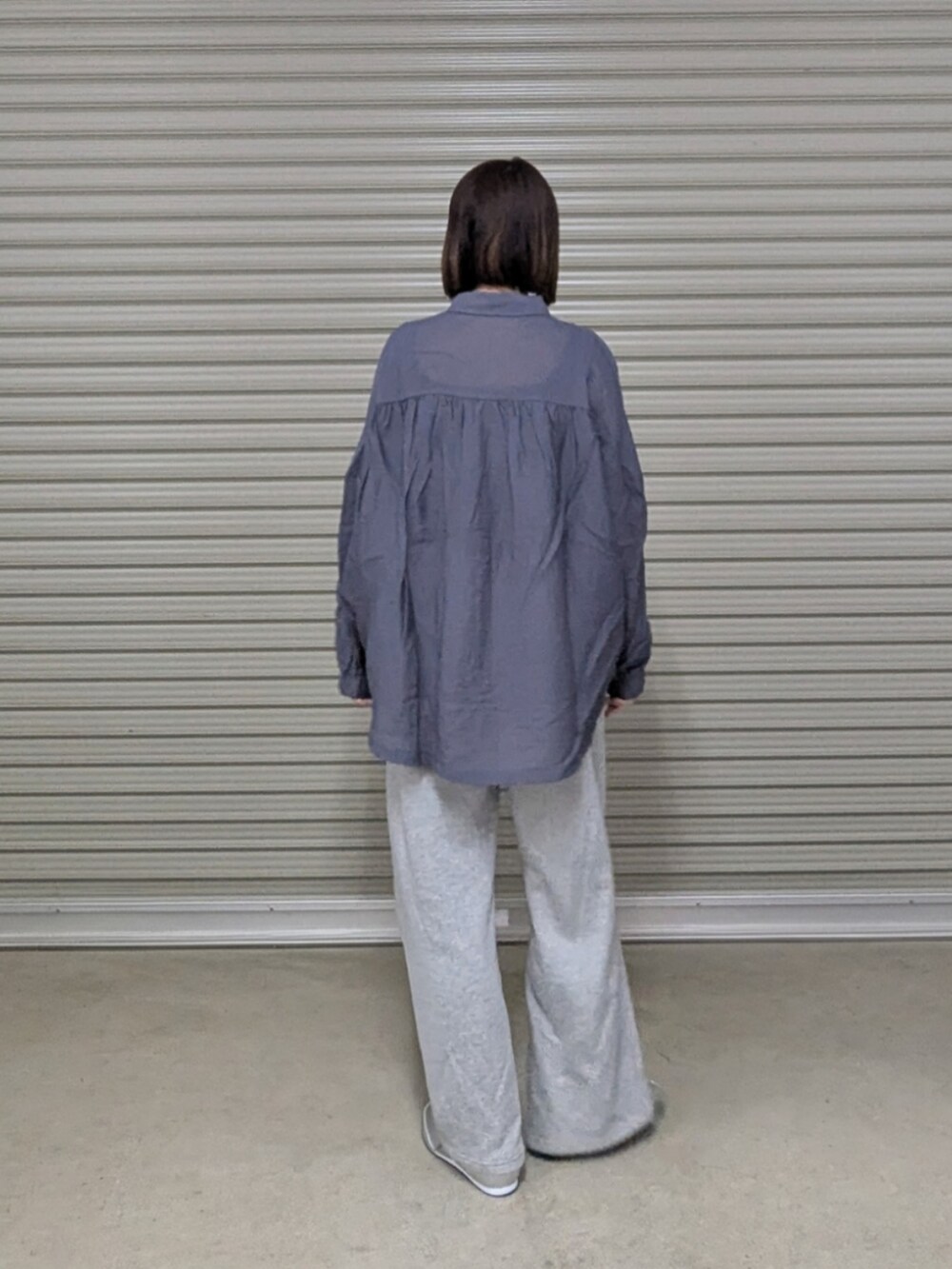 グレー系のシャツ/ブラウス、シルバー系のトートバッグ、グレー系のパンツを着用したレディースの春コーディネートの3枚目の写真