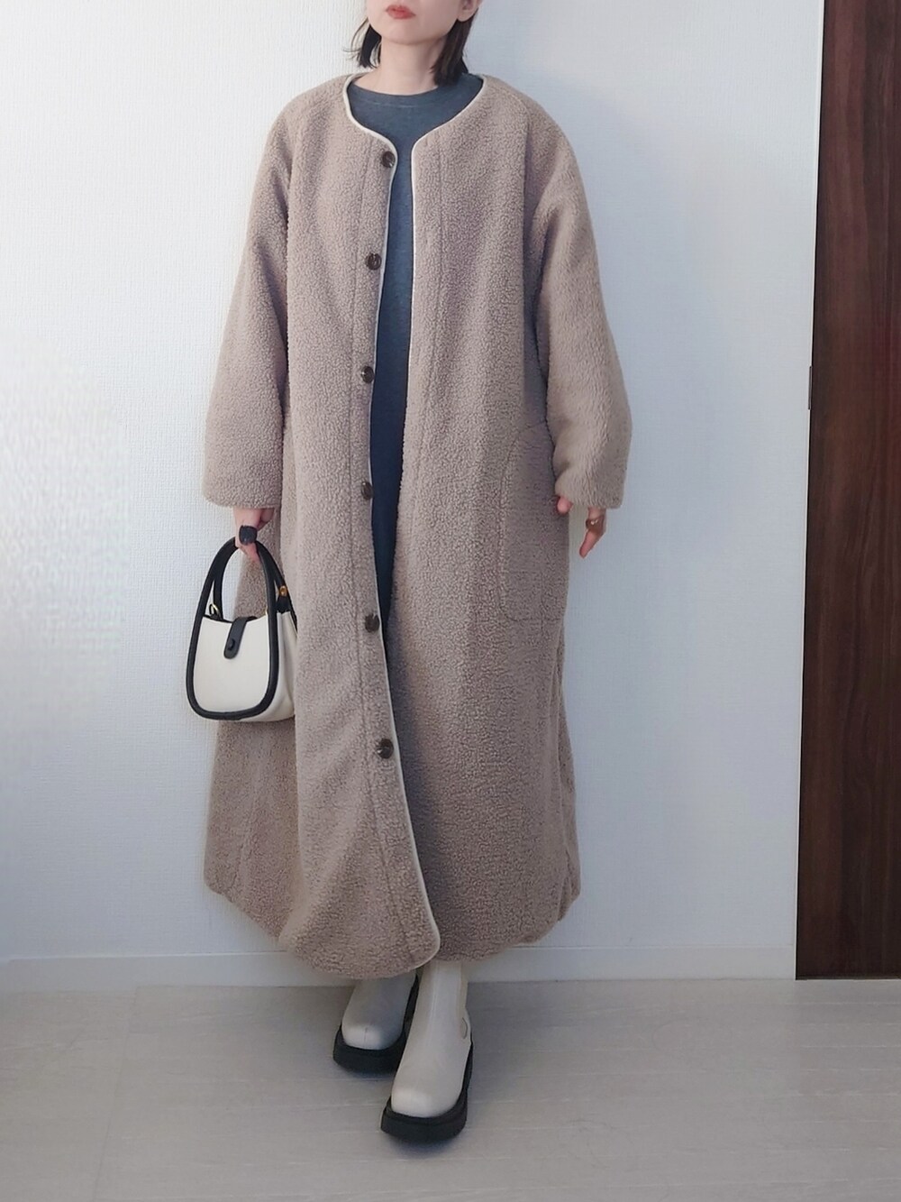 ホワイト系のその他アウター、ブラック系のスウェット、ブルー系のデニムパンツを着用したレディースの秋コーディネートの3枚目の写真