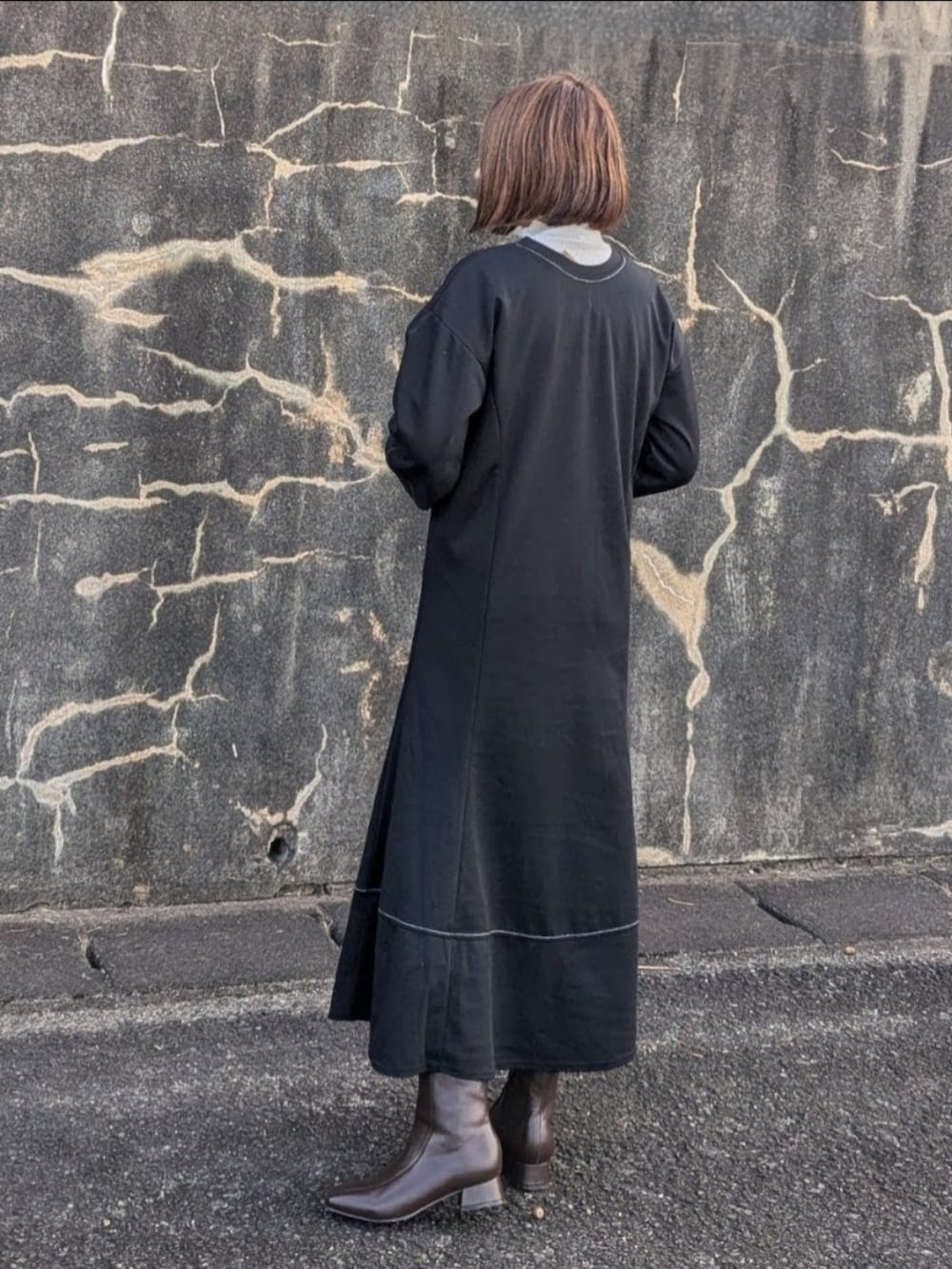 ブラック系のワンピース、ホワイト系のTシャツ/カットソー、ベージュ系のショルダーバッグを着用したレディースの秋コーディネートの3枚目の写真