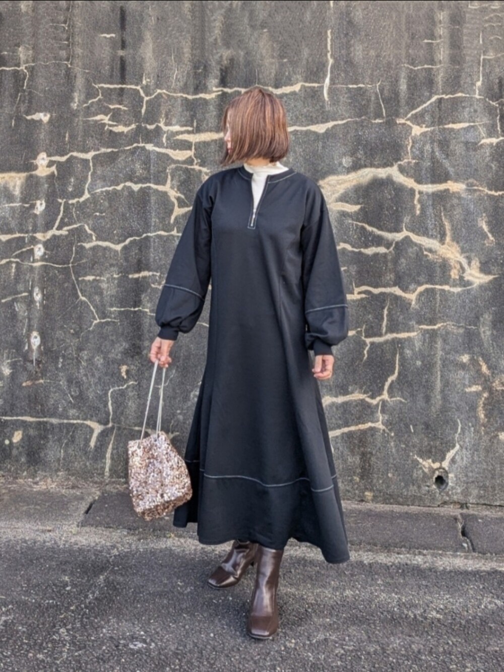 ブラック系のワンピース、ホワイト系のTシャツ/カットソー、ベージュ系のショルダーバッグを着用したレディースの秋コーディネートの2枚目の写真