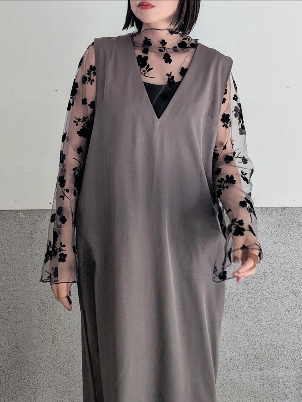 ブラウン系のその他トップス、グレー系のジャンパースカート、ホワイト系のハンドバッグを着用したレディースの冬コーディネートの3枚目の写真