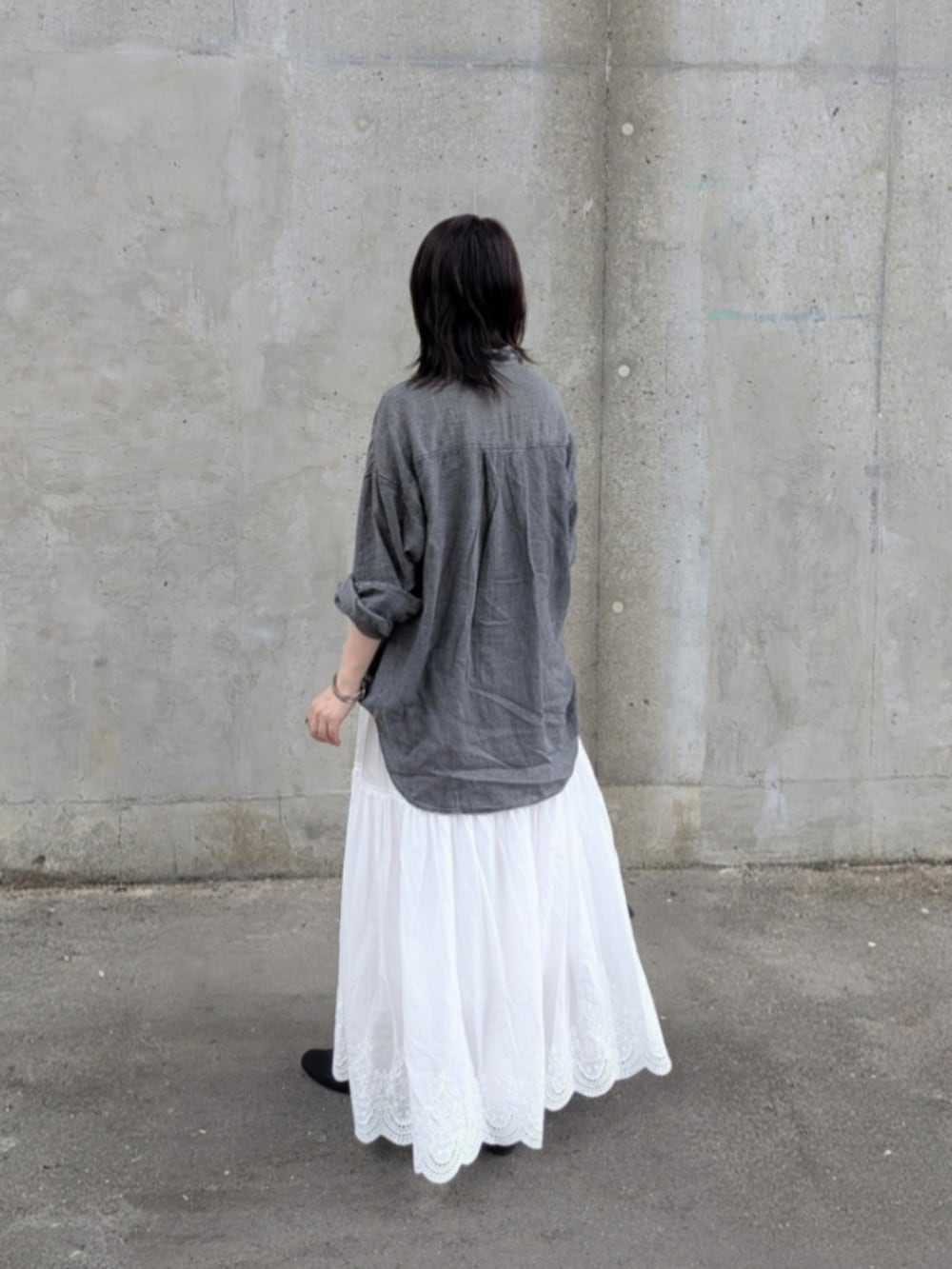 ホワイト系のスカート、ブラック系のシャツ/ブラウス、ブラック系のパンプスを着用したレディースの夏コーディネートの2枚目の写真