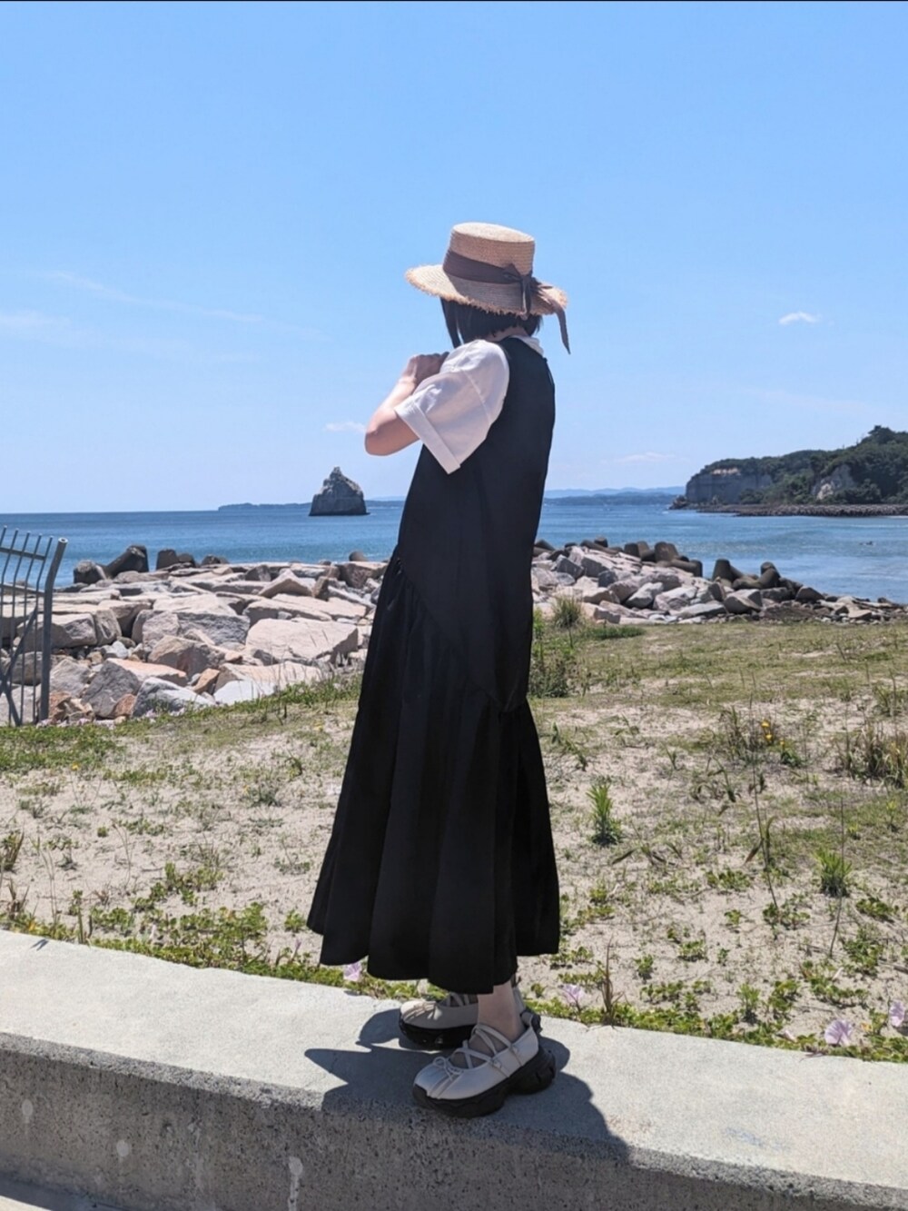 ブラック系のワンピース、ホワイト系のTシャツ/カットソー、ブラック系のショルダーバッグを着用したレディースの夏コーディネートの2枚目の写真