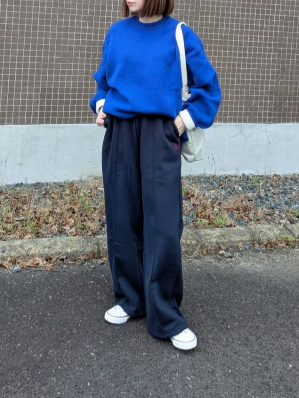 ブルー系のスウェットパンツ、ブルー系のニット/セーター、ホワイト系のトートバッグを着用したレディースの秋コーディネートの2枚目の写真
