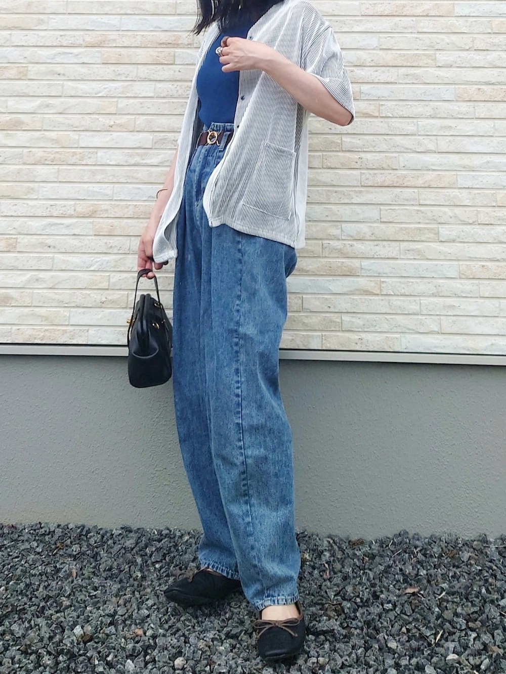 ブルー系のニット/セーター、ホワイト系のシャツ/ブラウス、ブラック系のショルダーバッグを着用したレディースの夏コーディネートの2枚目の写真