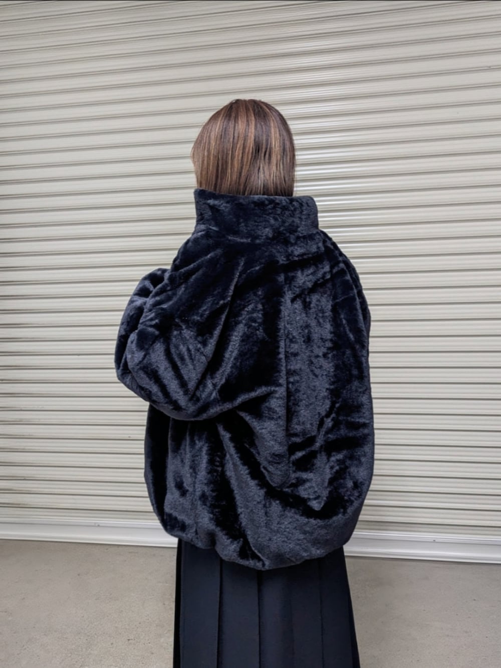 ブラック系のブルゾン、ブラウン系のニット/セーター、ブラック系のブーツを着用したレディースの秋コーディネートの3枚目の写真