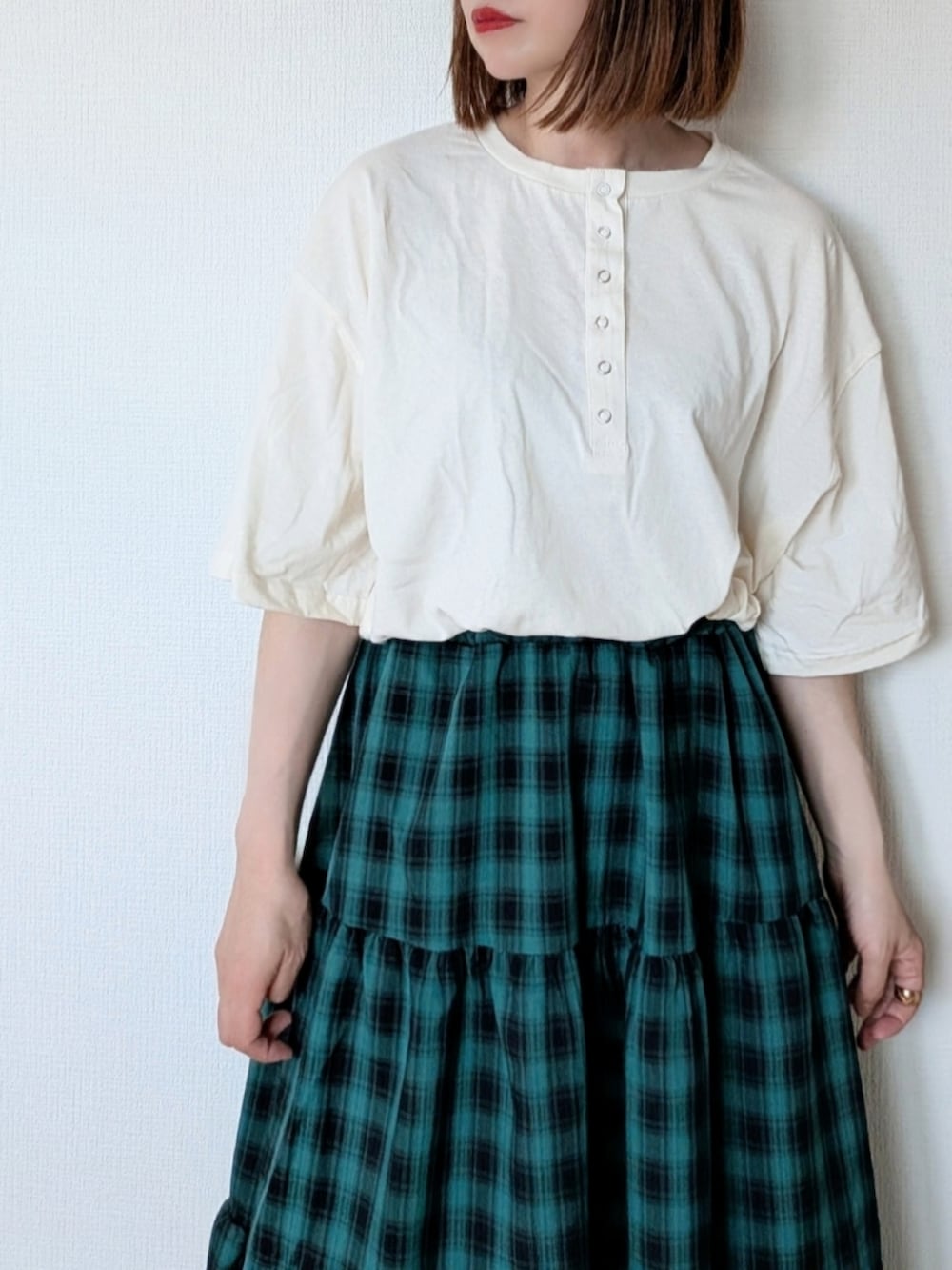 ホワイト系のTシャツ/カットソー、グレー系のショルダーバッグ、グリーン系のスカートを着用したレディースの夏コーディネートの2枚目の写真