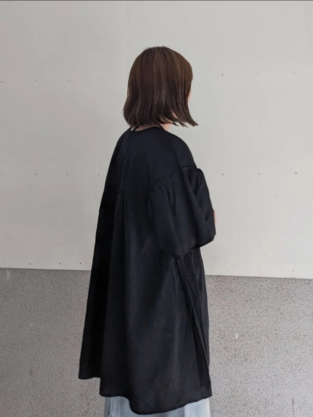 ブラック系のシャツ/ブラウス、ブルー系のスカート、ホワイト系のハンドバッグを着用したレディースの夏コーディネートの3枚目の写真