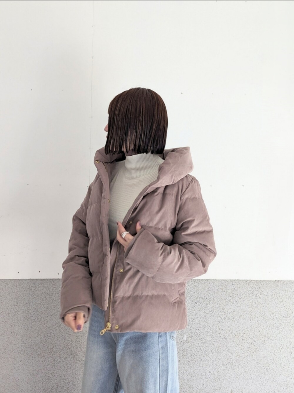 レッド系のダウンジャケット/コート、ブルー系のデニムパンツ、ブラック系のショルダーバッグを着用したレディースの冬コーディネートの2枚目の写真