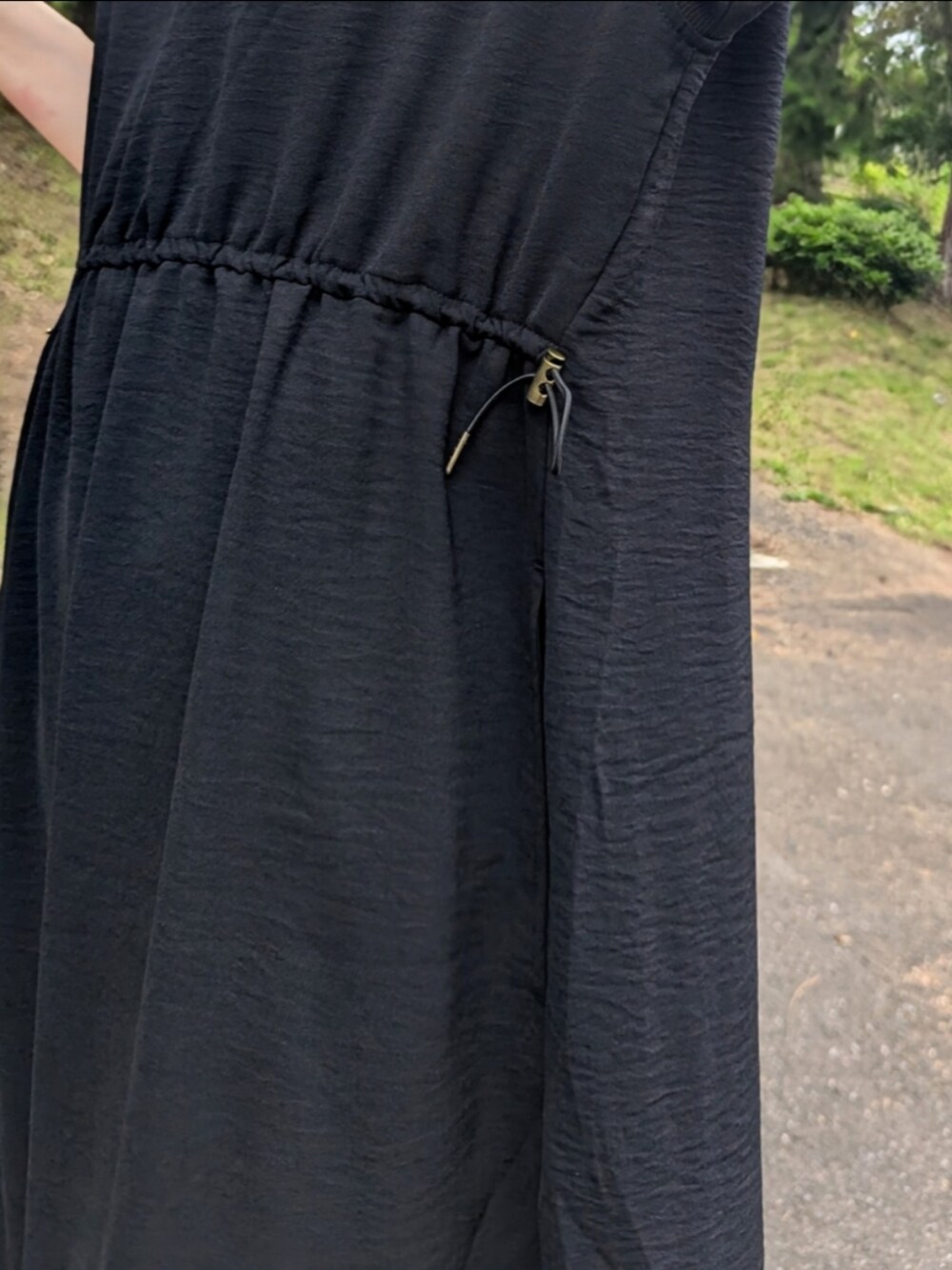 ブラック系のワンピース、オレンジ系のトートバッグ、ブラック系のサンダルを着用したレディースの夏コーディネートの4枚目の写真